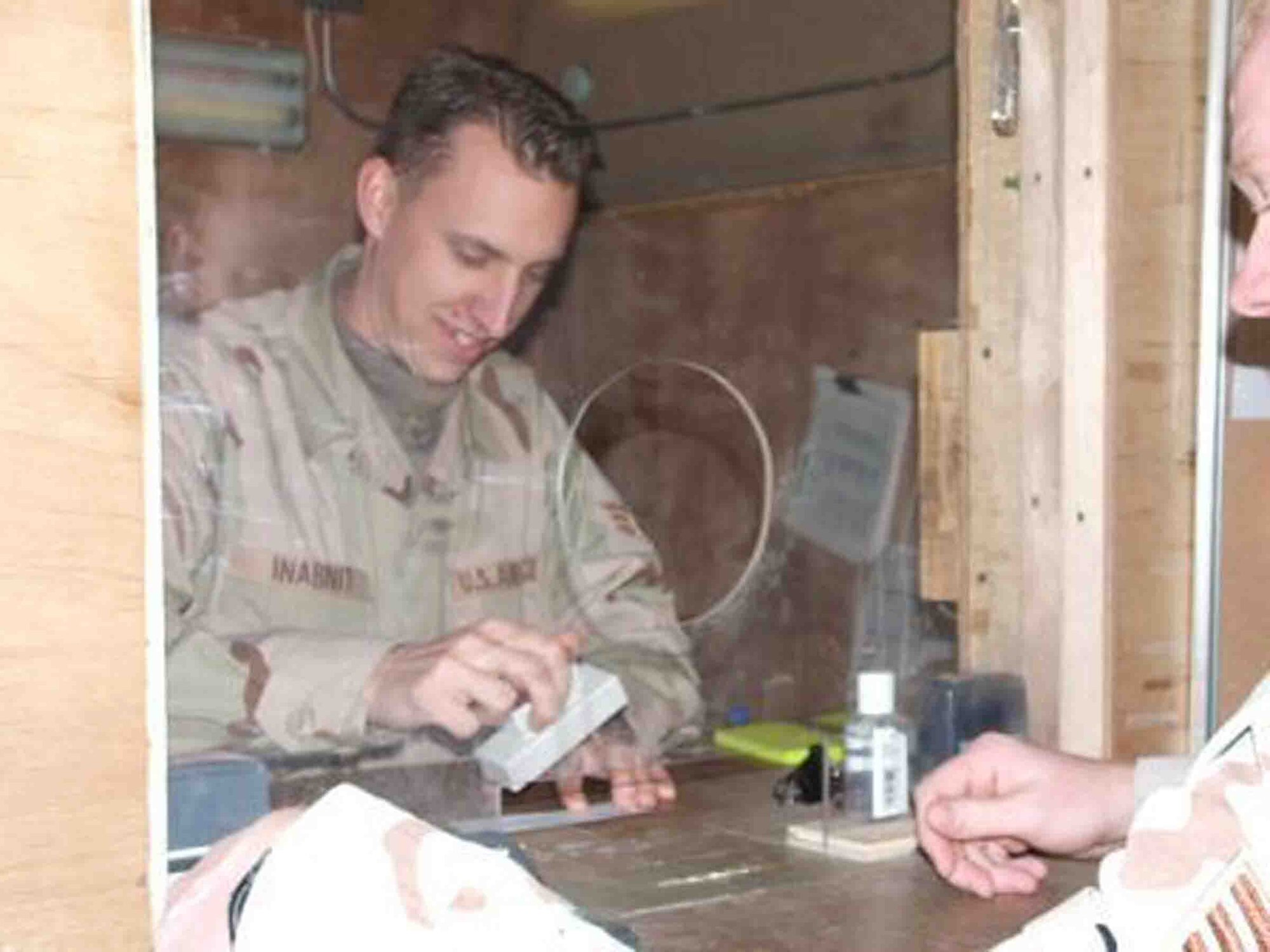 BALAD AIR BASE, Iraq -- Senior Airman Richard Inabnit cashes a check Jan. 26 for an Airman. Airman Inabnit is deployed from Shaw Air Force Base, S.C., where he is assigned to the 20th Comptroller Squadron. (Courtesy photo)