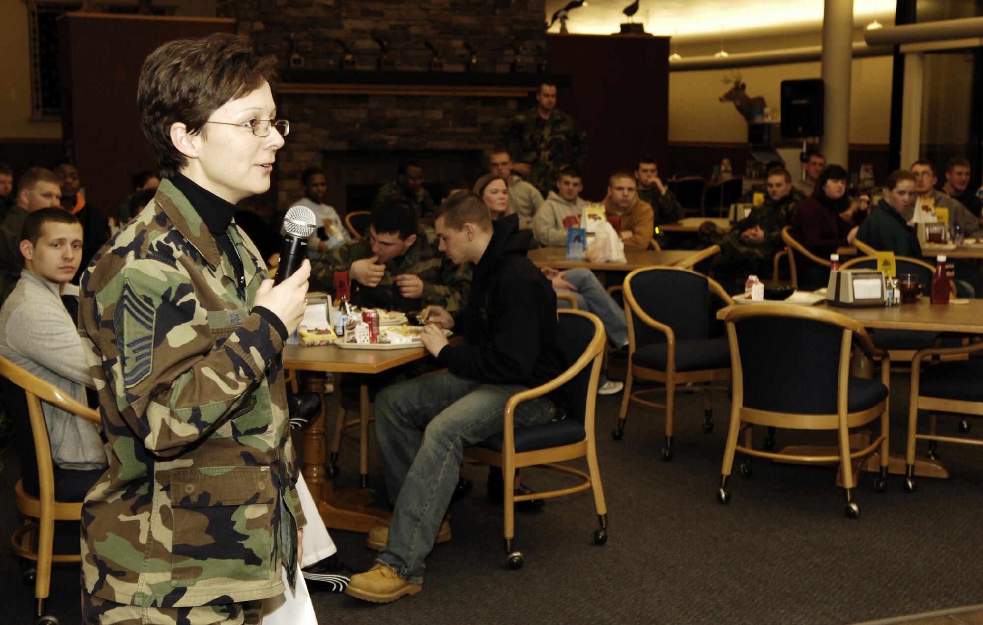 Chief Master Sgt. Judith Ruiz, acting 92nd Air Refueling Wing command chief, introduces the wing commander during a roll call with dormitory residents Jan. 26 at the Warrior Dining Facility. The purpose of the roll call was to emphasize responsible choices with Fairchild?s Airmen, as well as discuss some different things going on around the base.