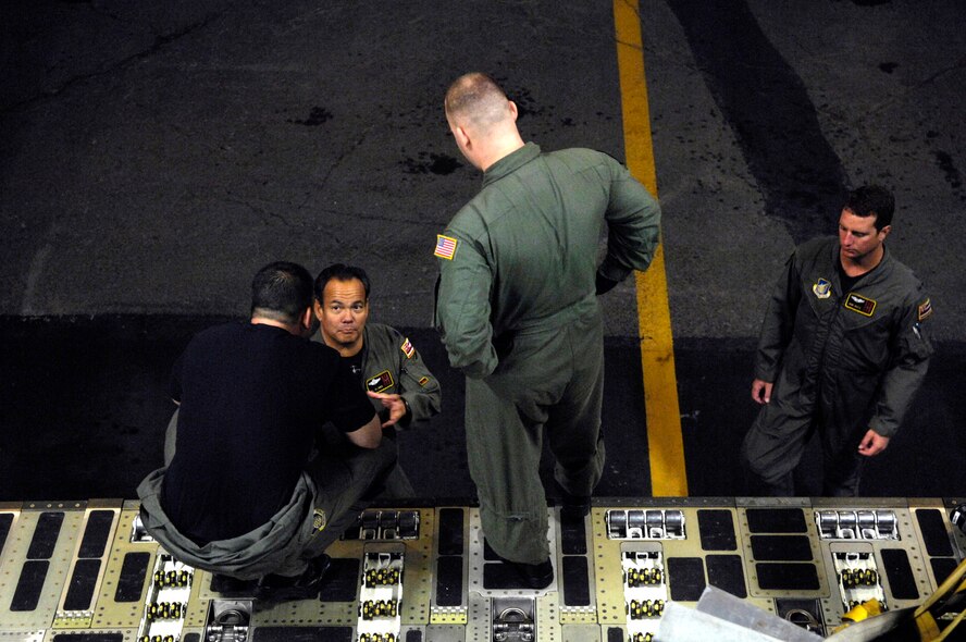 Staff Sgt. Jason Scaffidi talks with other C-17 Globemaster III crew members before departing for a mission Jan. 25 from Hickam Air Force Base, Hawaii. Sergeant Scaffidi is a loadmaster with the 535th Airlift Squadron. The C-17 Globemaster III is capable of rapid strategic delivery of troops and all types of cargo to main operating bases or directly to forward bases in the deployment area. (U.S. Air Force photo/Tech. Sgt. Shane A. Cuomo) 