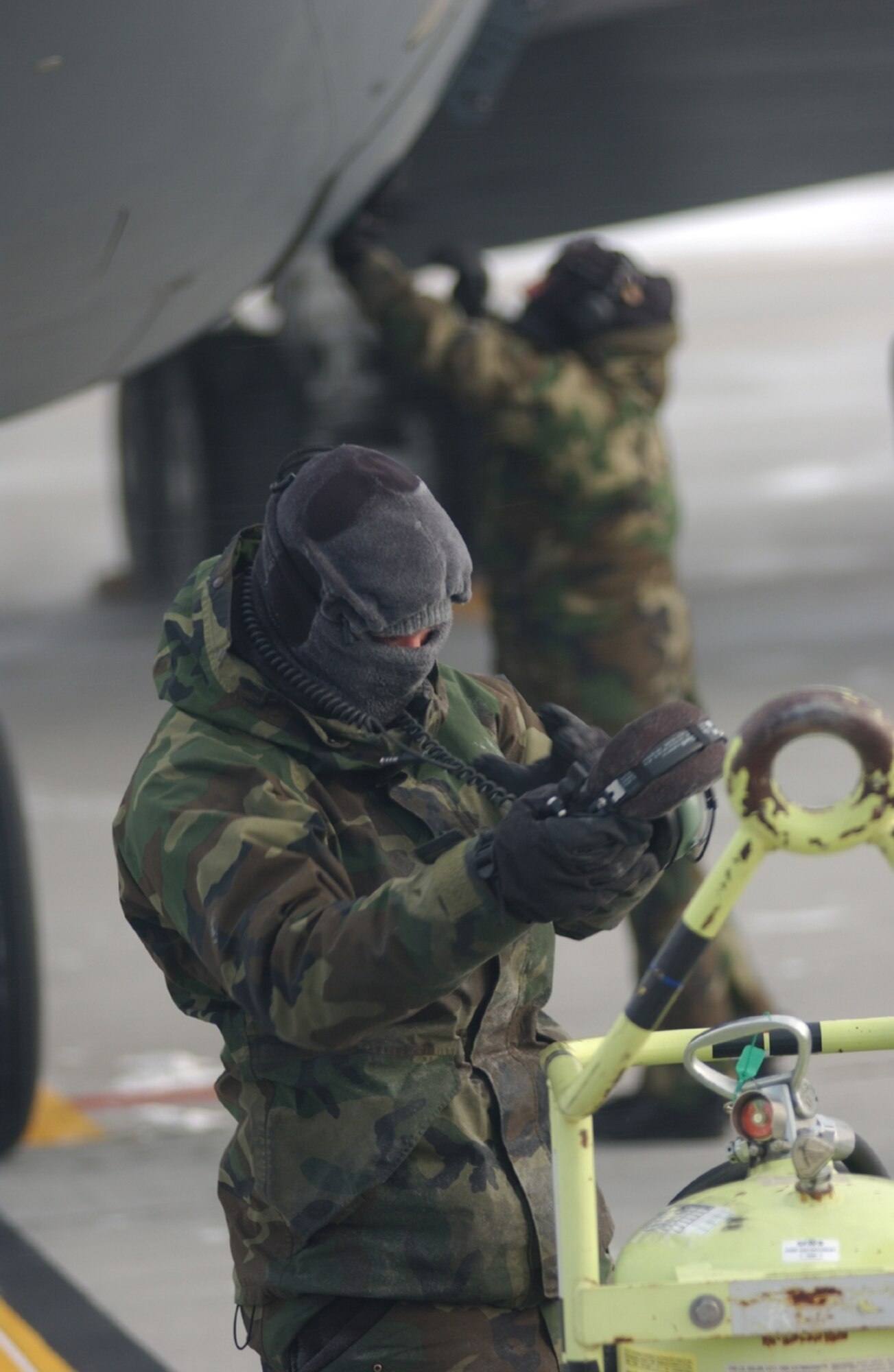 A crew chief with the 319th Aircraft Maintenance Squadron adjusts his headset here Jan. 29 during a post-flight inspection. Crew chiefs routinely work in sub-zero temperatures here. On this day, the wind chill index was minus 22.  (U.S. Air Force photo/Senior Airman J.Paul Croxon) 