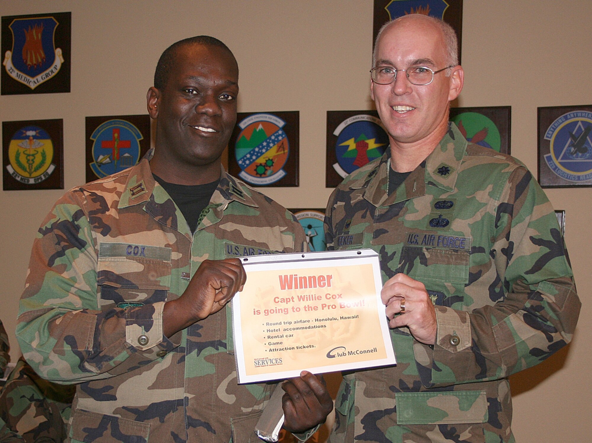 Lt. Col. Scott Meeker, right, 22nd Services Squadron commander, hands Capt. Willie Cox, 22nd Logistics Readiness Squadron, a certificate Dec. 21 awarding him two tickets to the National Football League’s Pro Bowl game, which will be played Feb. 10 in Honolulu, Hawaii. In addition to Pro Bowl tickets, Captain Cox won an all-expenses-paid, six-day, five-night trip for two to Hawaii, including round trip airfare, hotel accommodations, a rental car and tickets to local attractions, courtesy of the Air Force’s Football Frenzy program. The program offers club members opportunities to win prizes ranging from T-shirts to Super Bowl tickets by watching games at their local base clubs. (Photo by Petty Officer 2nd Class Troy Karr, 22nd ARW Public Affairs)