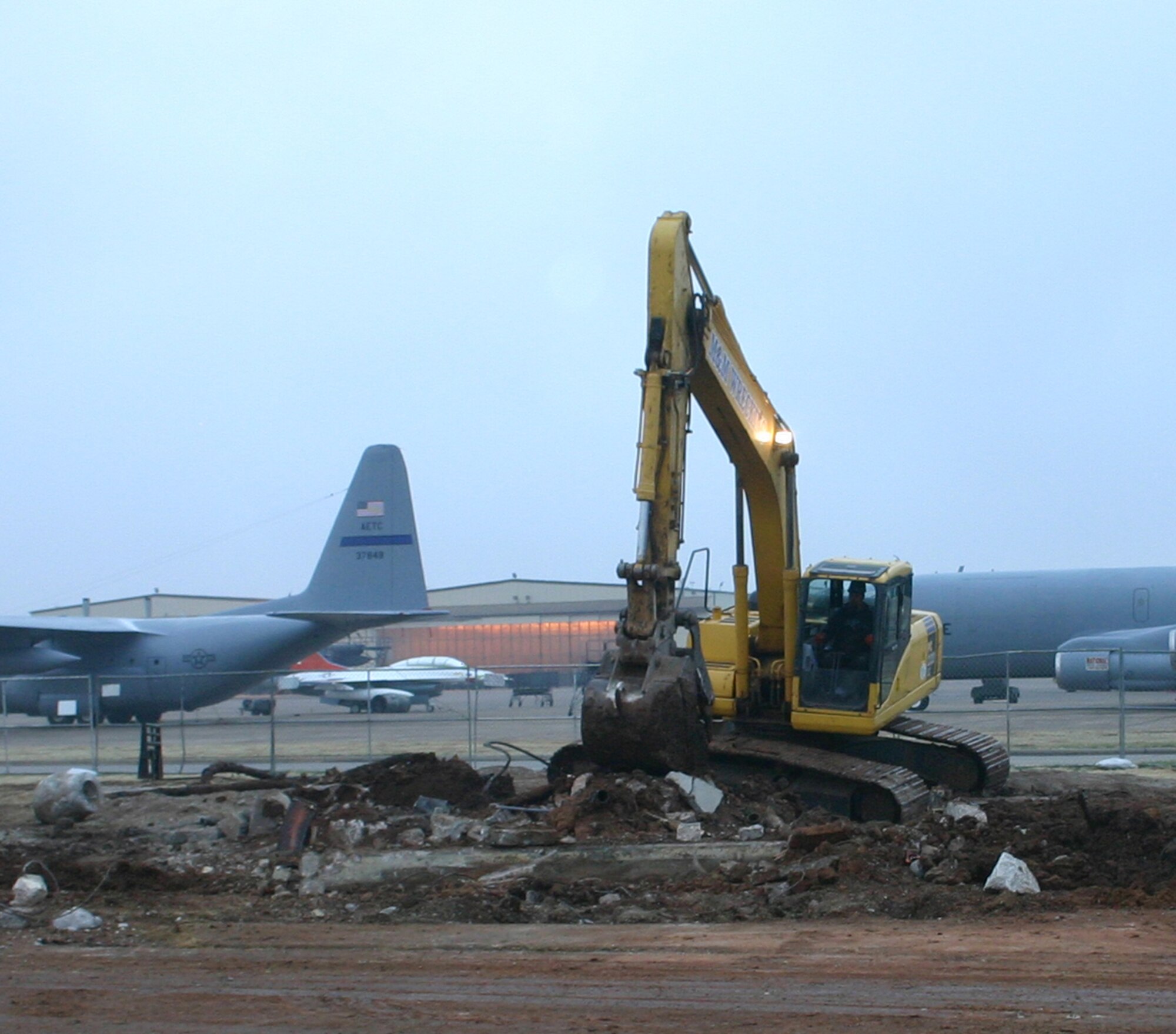 Charlie Mason, a track hoe operator with M&M Wrecking, slowly digs up the underground piping and concrete foundation of the old control tower, which used to stand next to Bldg. 1093.  The new tower stands just a short distance away, also along the flight line. (U.S. Air Force Photo/SSgt Tonnette Thompson)