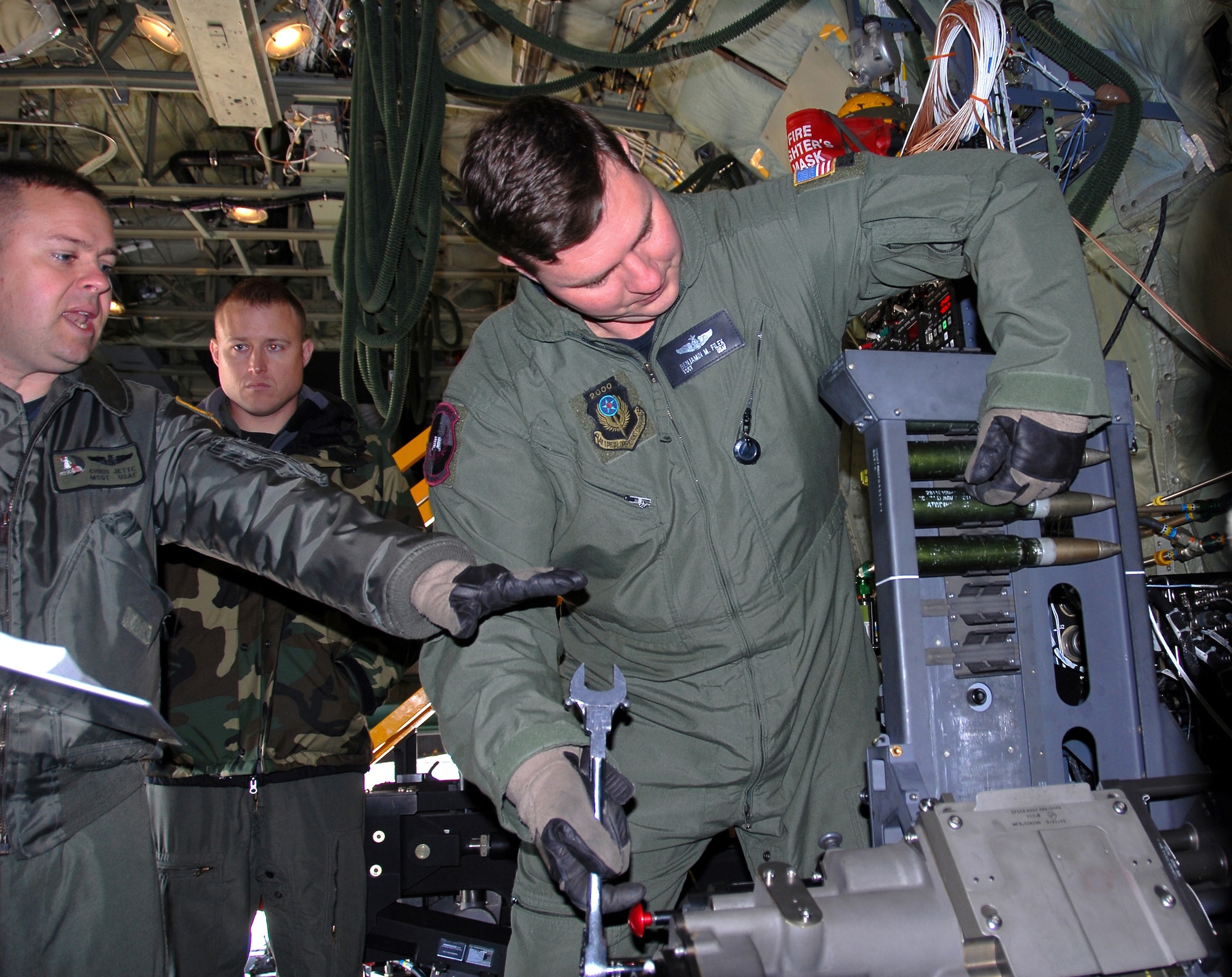 Lock and load - Master Sgt. Chris Jette, left, explains loading procedures for a 30mm Bushmaster cannon to Technical Sgt. Ben Filek while Technical Sgt. James Knight looks on.  The Airmen are aboard an AC-130U Spooky gunship at Hurlburt Field, Fla.  The 30 mm gun will eventually replace both the 40 mm cannon and 25 mm gun on U-model gunships.  Sergeant Jette is an aerial gunner with the 1st Special Operations Group standardization/evaluation section at Hurlburt Field, Sergeants Filek and Knight are aerial gunners with the 19th Special Operations Squadron at Hurlburt. (Air Force photo by Chief Master Sgt. Gary Emery) 
