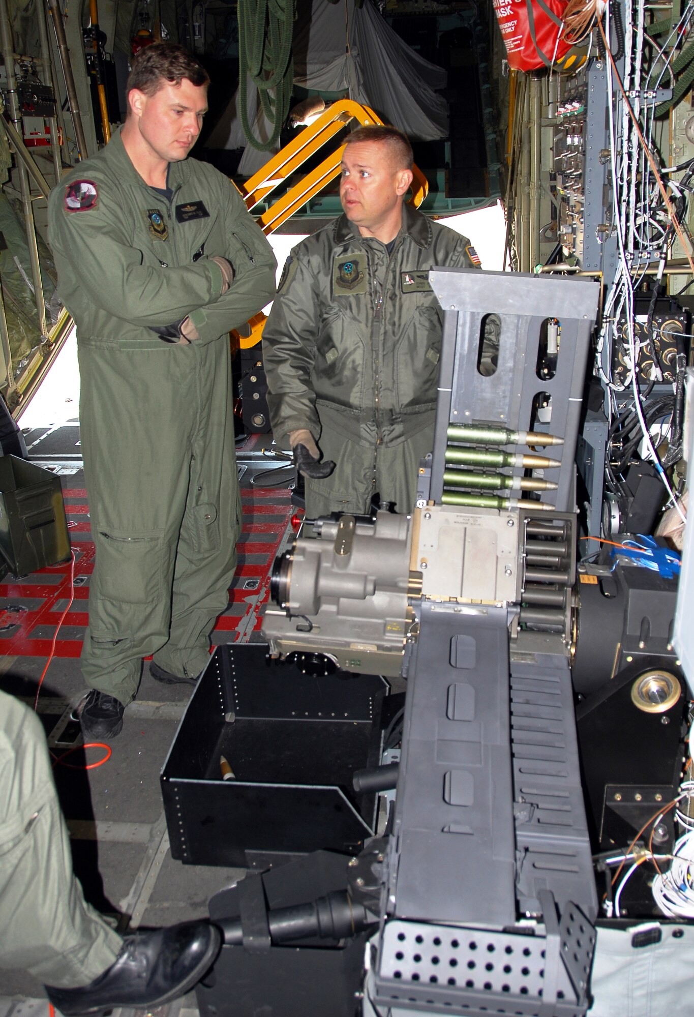 Technical Sgt. Ben Filek, left, and Master Sgt. Chris Jette look over a newly-installed 30 mm Bushmaster cannon aboard an AC-130U Spooky gunship. Sergeant Filek is an aerial gunner with the 19th Special Operations Squadron at Hurlburt Field, Fla.  Sergeant Jette, also an aerial gunner, is with the 1st Special Operations Group standardization/evaluation section at Hurlburt.  The 30 mm gun will eventually replace both the 40 mm cannon and 25 mm gun on U-model gunships.  (Air Force photo by Chief Master Sgt. Gary Emery)