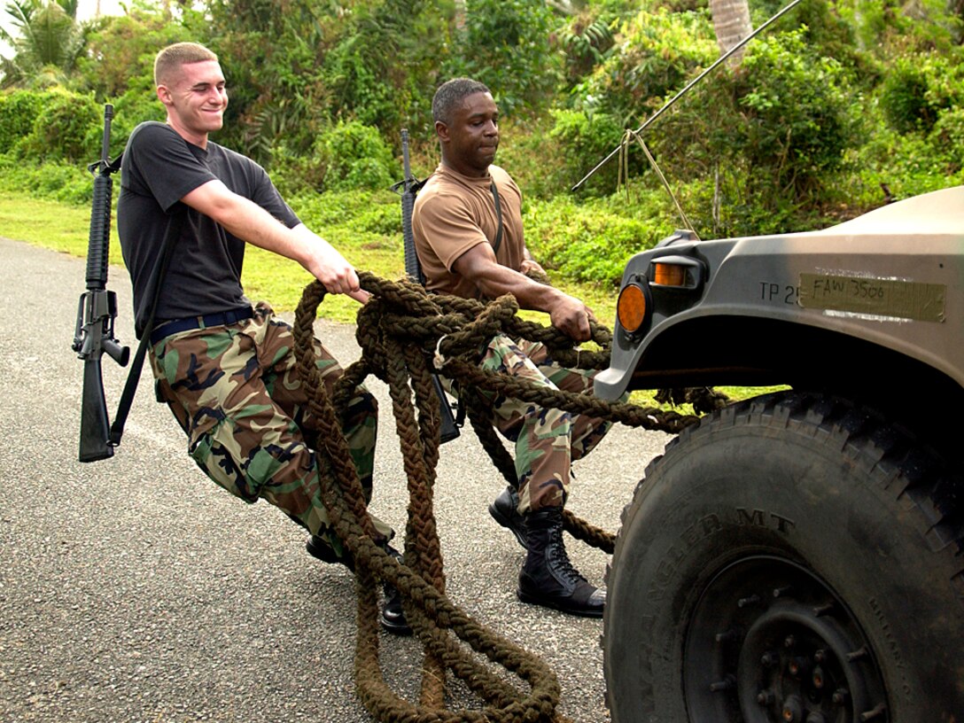 Senior Airman Arthur Loosemore and Capt. Samuel Glass pull a Humvee up a hill at Checkpoint 3 during Warrior Day Jan. 26 at Checkpoint 4 at Andersen Air Force Base, Guam. The two are members of the 36th Comptroller Squadron, and were part of the 84 Airmen in 21 teams who competed in the two-day competition. (U.S. Air Force photo/Senior Airman Miranda Moorer) 
