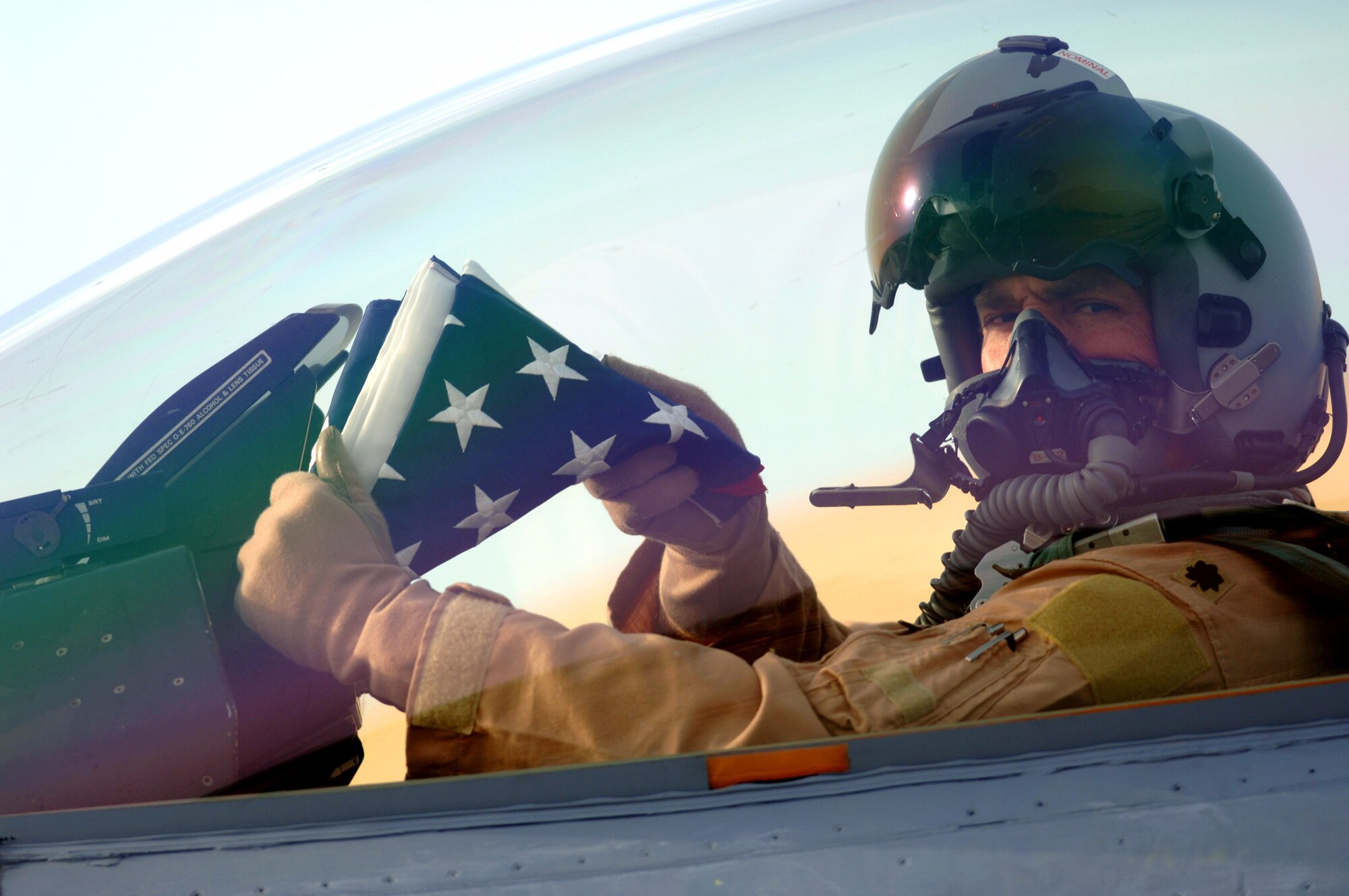Lt. Col. Chris Ashby sits in an F-16 Fighting Falcon and displays the U.S. flag before departing on a combat mission over Iraq, Jan. 29 from Balad Air Base, Iraq. Colonel Ashby is the 332nd Air Expeditionary Wing chief of Safety deployed from the 20th Fighter Wing, Shaw Air Force Base, S.C. (U. S. Air Force photo/Staff Sgt. Michael R. Holzworth)

