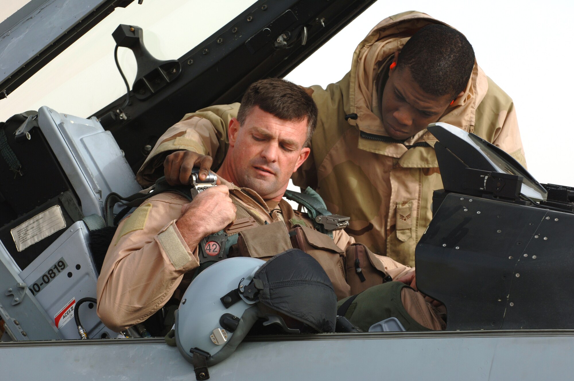 Lt. Col. Chris Ashby gets assistance strapping into an F-16 Fighting Falcon from  Senior Airman Robert Gattison before departing for a combat mission Jan. 29 at Balad Air Base, Iraq. Colonel Ashby is the 332nd Air Expeditionary Wing chief of safety from the 20th Fighter Wing at Shaw Air Force Base, S.C. Airman Gattison is a crew chief assigned to the 14th Expeditionary Aircraft Maintenance Squadron. (U. S. Air Force photo/Staff Sgt. Michael R. Holzworth)
