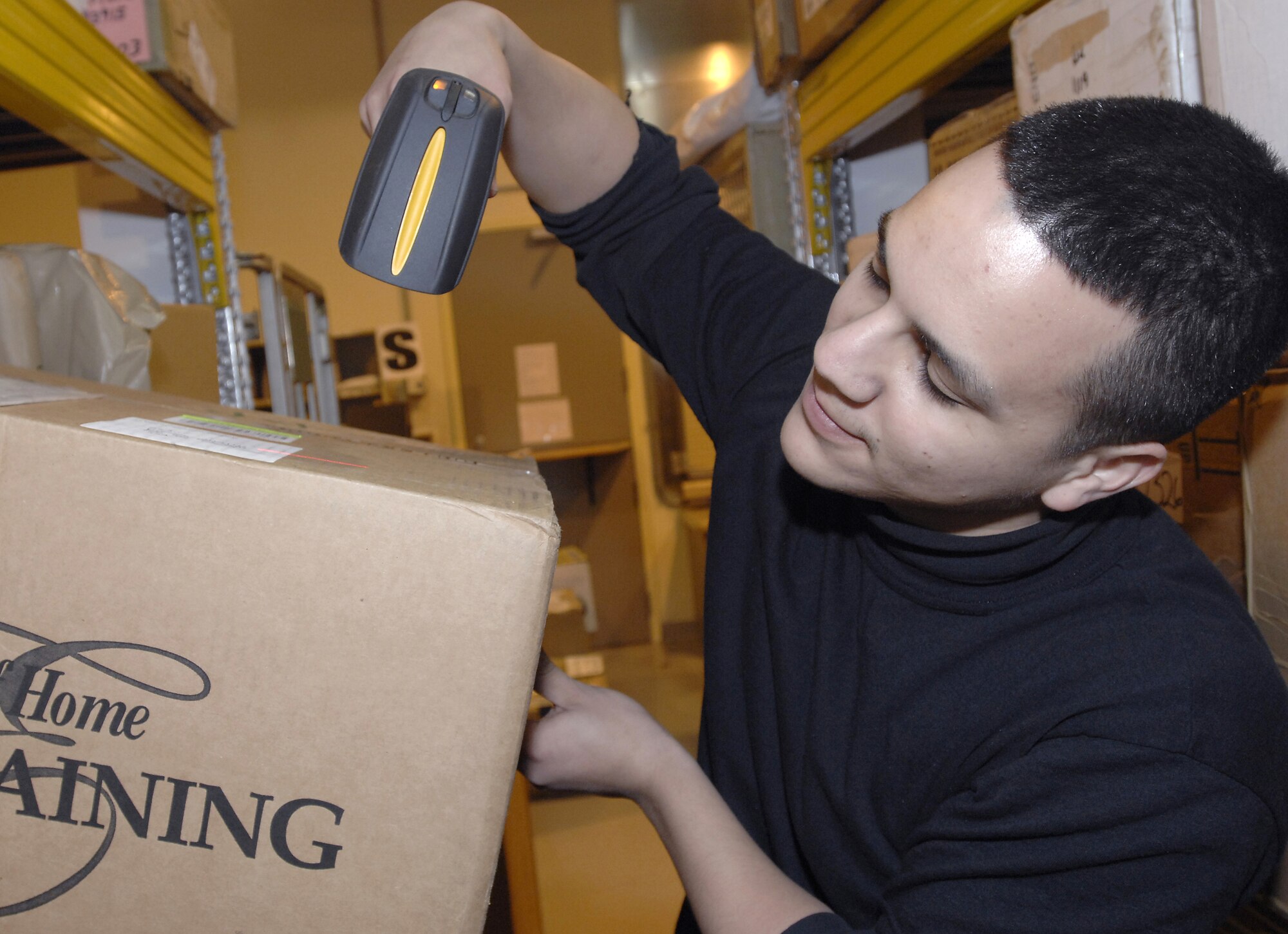 Airman 1st Class Erick Cruz, 31st Communications Squadron postal clerk, scans a box to keep track of packages going in and out of the Aviano Post Office January 27. (Photo by Airman 1st Class Liliana Moreno)