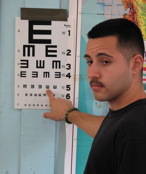 KORAT, Thailand -- Senior Airman David Hernandez, an optometry technician with the 374th Medical Group from Yokota Air Base, Japan, uses a tumbling E chart to gauge visual acuity during and eye exam at the Ban Chai Mong Khon School. Airmen Hernandez is one of 14 medical and dental personnel from bases throughout the Pacific participating in the Exercise Cope Tiger 2007 Humanitarian Civil Action projects in Thailand. The tumbling E chart is used when language or literacy is an obstacle when giving an exam. (Photo by U.S. Army Sergeant Catherine Talento)