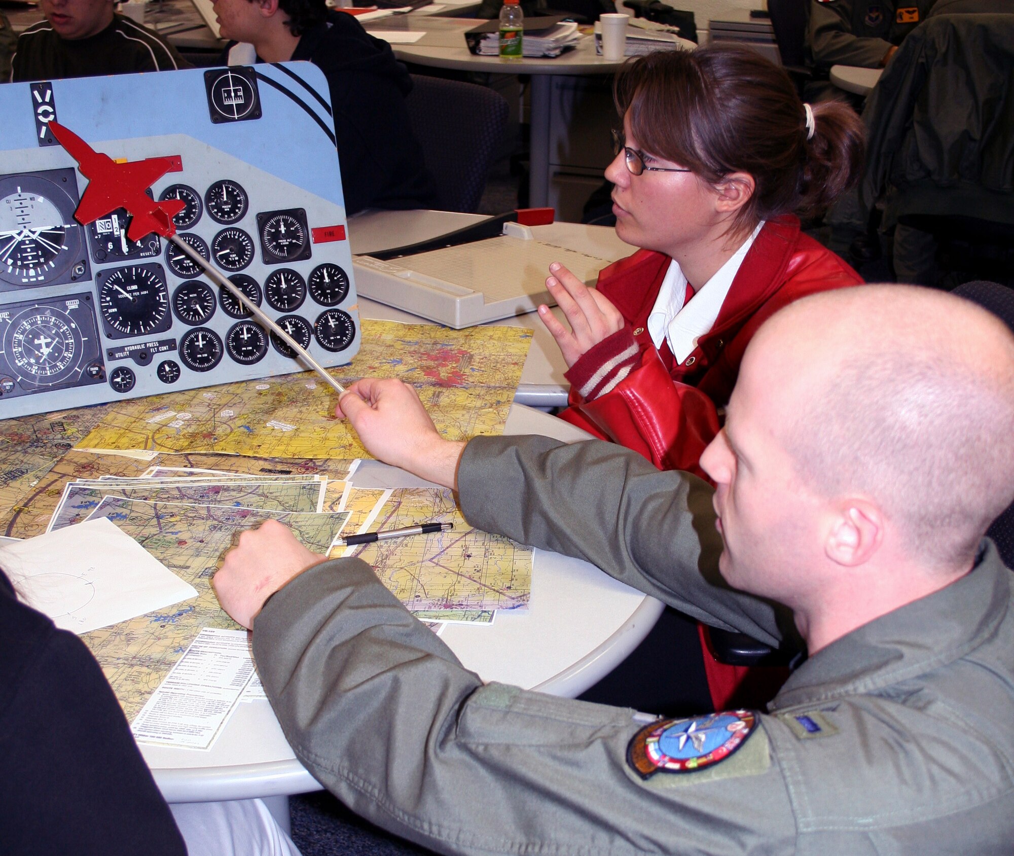 An instructor pilot from the 90th Flight Training Squadron, 1st Lt. Dan Summers, explains the cockpit training aid to Oleny High School senior Eilise Burns during the 11th Annual Groundhog Job Shadowing Career Day Feb. 2. (U.S. Air Force photo/Adrian McCandless)
