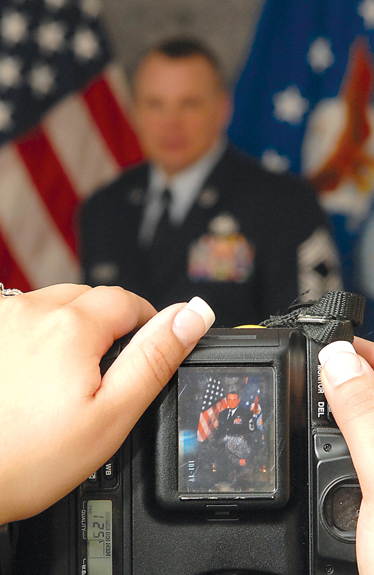 Senior Airman Heather Redman, 27th Communications Squadron, views an official photo taken of Chief Master Sgt. John Wood, 27th Operations Group on Jan 30 at Cannon Air Force Base, N.M. Photograhers in the Air Force will soon merge into the public affairs career field. (Air Force photo/Airman 1st Class Randi Flaugh)