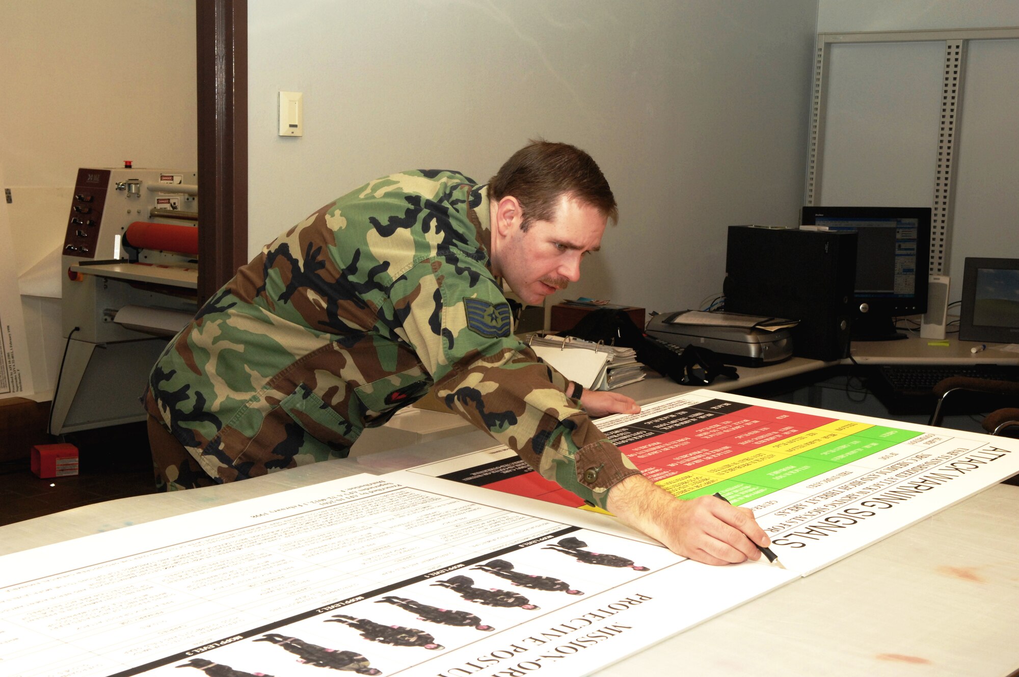 Tech. Sgt. Ronald Flack, 27th Communications Squadron graphics artist, prepares a display board on Jan. 30 for an upcoming Phase II exercise at Cannon Air Force Base N.M. The graphics career field will soon phase out as multimedia merges with the public affairs career field. (Air Force photo/Airman 1st Class Randi Flaugh)