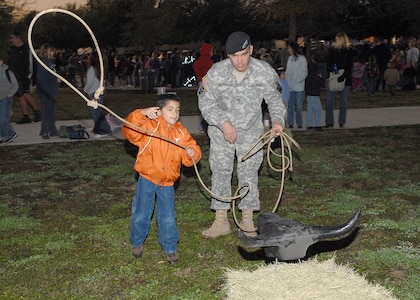 Jacob Hernandez, 6, a kindergarten student at Lackland Elementary School, tries to lasso a makeshift bull Jan. 26 during the 3rd Annual Lackland Independent School District Cowboy Breakfast. Encouraging his son is Army Staff Sgt. Jacob Hernandez, an analyst in Lackland's 314th Military Intelligence Battalion. The breakfast was "a rip-roaring success," attracting its largest crowd yet, about 460 students, parents and teachers, said the coordinator, Librarian Robbye Durham. She said students learn about Texas' ranching history in the week preceding the breakfast, held the same morning as the city's annual Cowboy Breakfast kickoff for the San Antonio Stock Show & Rodeo. (USAF photo by Robbin Cresswell)