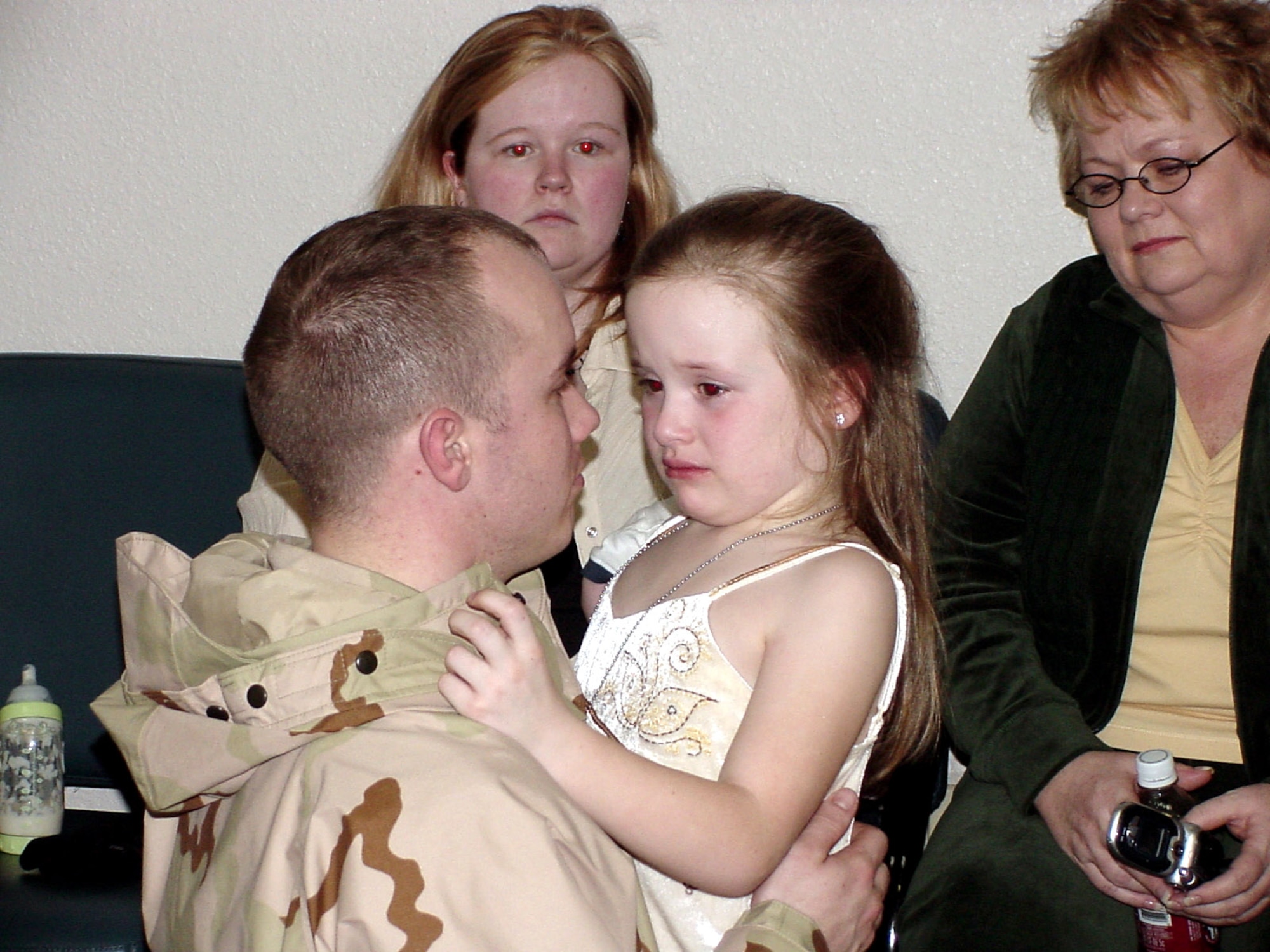 Staff Sgt. Jonathon Cagle comforts his daughter, Skylar, Jan. 17 before leaving for Afghanistan from Travis Air Force Base, Calif. Sergeant Cagle, a biomedical equipment repair technician assigned to the 60th Medical Support Squadron, is one of more than 100 Airmen from the 60th Medical Group who have deployed to Bagram Air Base, Afghanistan, to staff the Air Force Theater Hospital there. (U.S. Air Force photo/Jim Spellman) 

