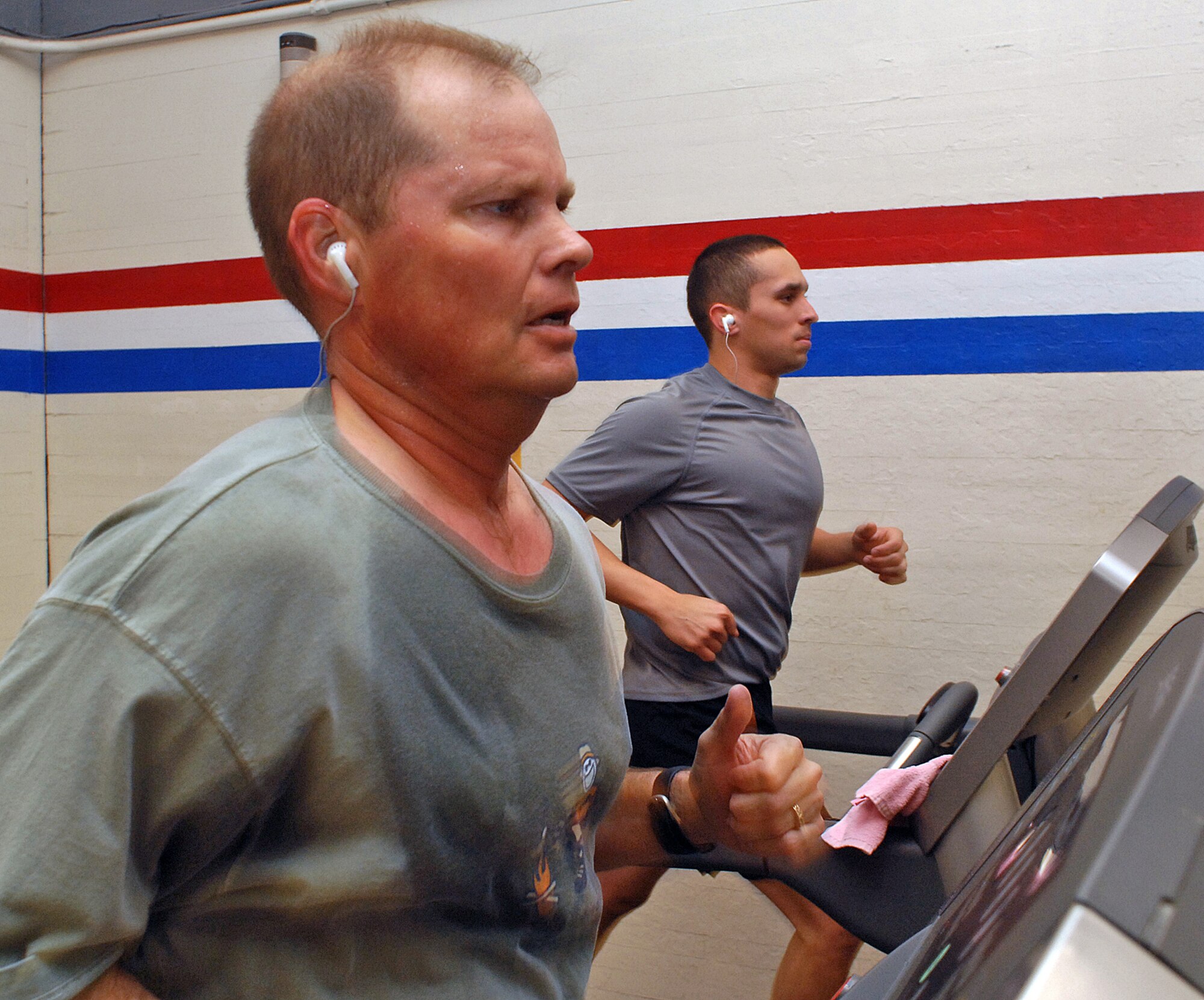 Lt. Col. Kurt Austin, Air Force Operational Test and Evaluation Center, and 1st Lt. Robert Lady, Space Development and Test Wing, run on tread mills at a fitness center here. (U.S. Air Force photo by Todd Berenger)