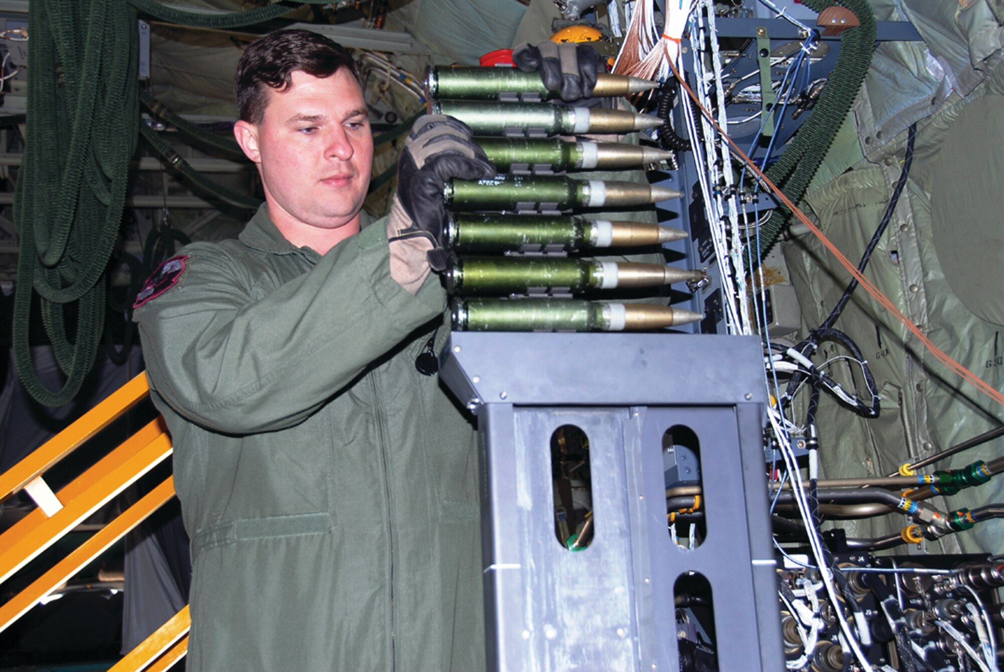 A 4th Special Operations Squadron gunner aboard an AC-130U Spooky loads the 30 mm ammunition into the seven-round clip that will feed into the gun. (Courtesy photograph)