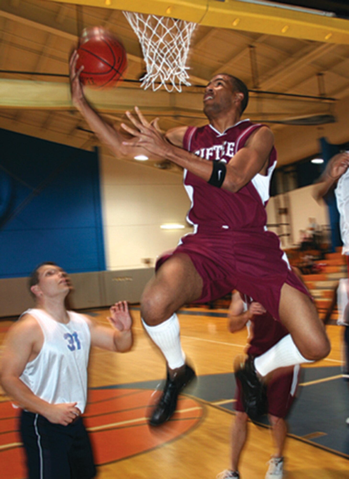 Warnia Daigle, 15th Aircraft Maintenance Unit intramural basketball team, goes in one-handed for the score Monday night against the Air Force Special Operations Command/Air Force Special Operations Forces team at the Aderholt Fitness Center. AMU defeated AFSOC/AFSOF, 73-57. (U.S. Air Force photograph by Dylan Laurie)