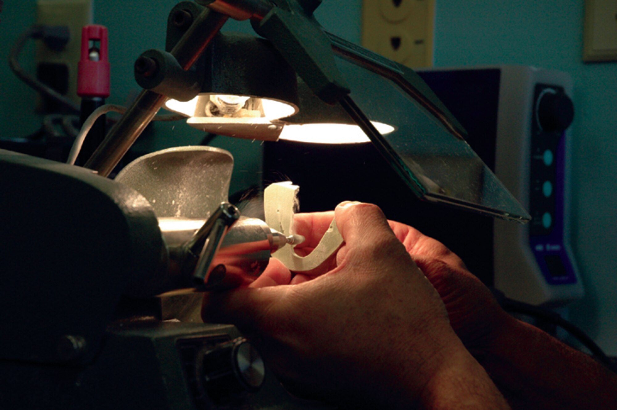 A dental technician grinds a patient's teeth cast. (U.S. Air Force photograph by Jamie Haig)