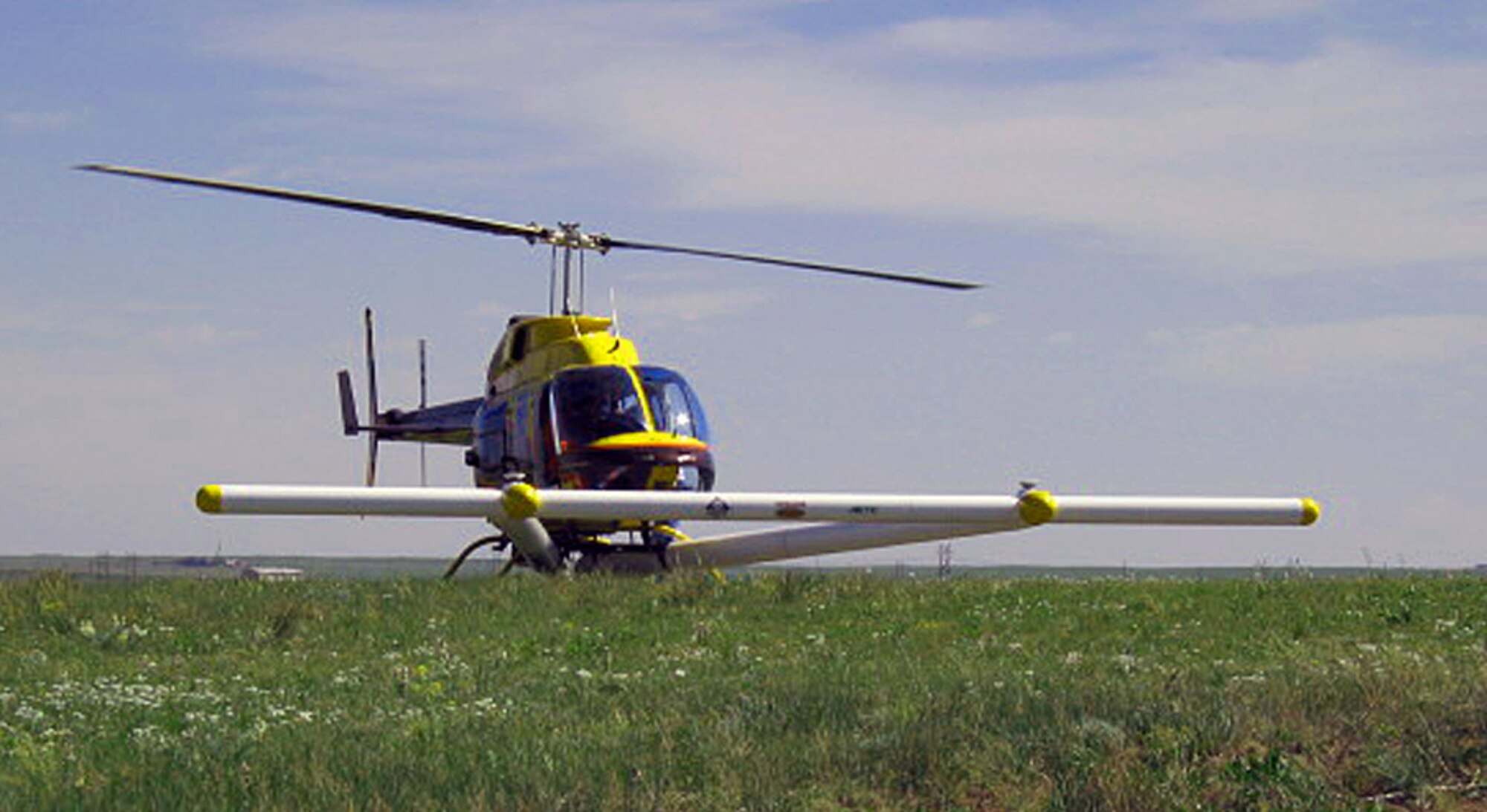 A helicopter with a metal detector mounted on it rests in a field. A helicopter such as this one will be flying over areas of Kirtland that were once used for munitions operations in the past. The helicopter will be searching for unexploded munitions and other debris. (Courtesy photo)