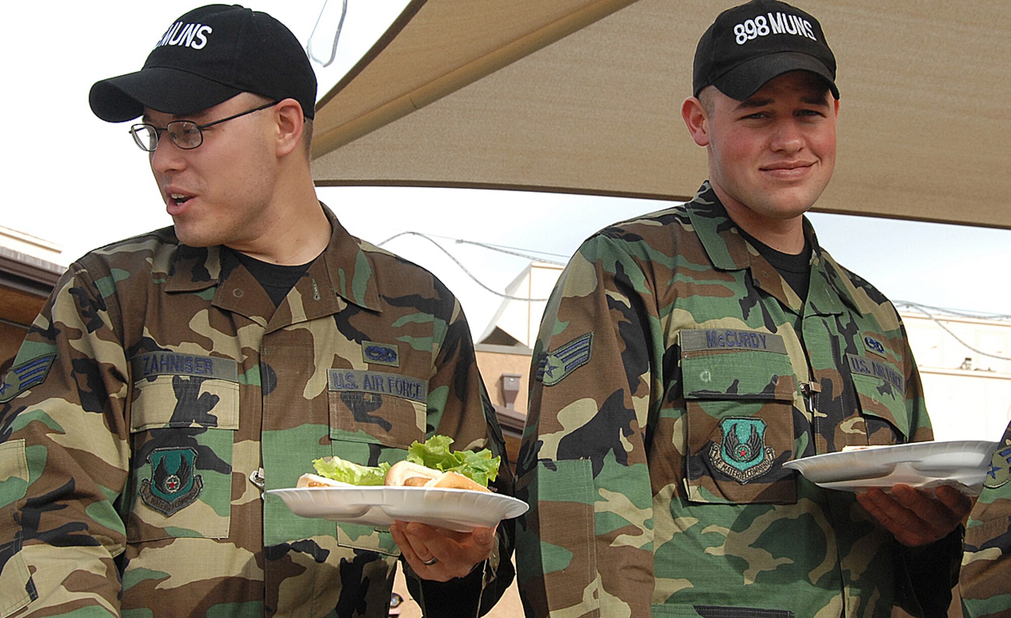 Senior Airmen Jeffery Zahniser and Asa McCurdy, 898th Munitions Squadron, get their food at the Nuclear Surety Inspection burger burn, here, Jan. 29. The picnic was held to celebrate the results of the inspection.