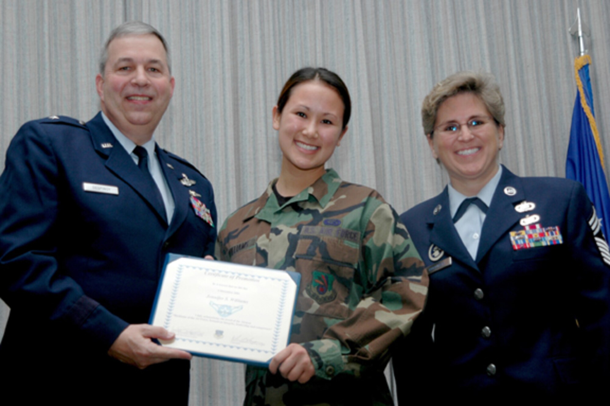 GRISSOM AIR RESERVE BASE, Ind., -- Airman Jennifer Williams, 434th Aircraft Maintenance Squadron, receives her first stripe from Brig. Gen. Dean Despinoy, 434th Air Refueling Wing commander during a promotion ceremony held during the January unit training assembly. Next to Airman Williams is Chief Master Sgt. Peri Rogowski, 434th ARW command chief. (Air Force Photo/Senior Airman Chris Bolen)