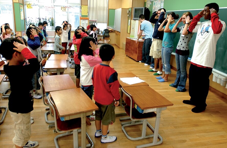 KADENA AIR BASE, Japan -- Members from Airmen Committed to Excellence sing the "Head, Shoulders, Knees and Toes" song with Okinawan children at Kitami Elementary School Jan. 19. Volunteers spent the afternoon singing songs and playing games geared toward learning various useful words, such as parts of the body, in English. (U.S. Air Force photo/Airman 1st Class Kelly Timney)