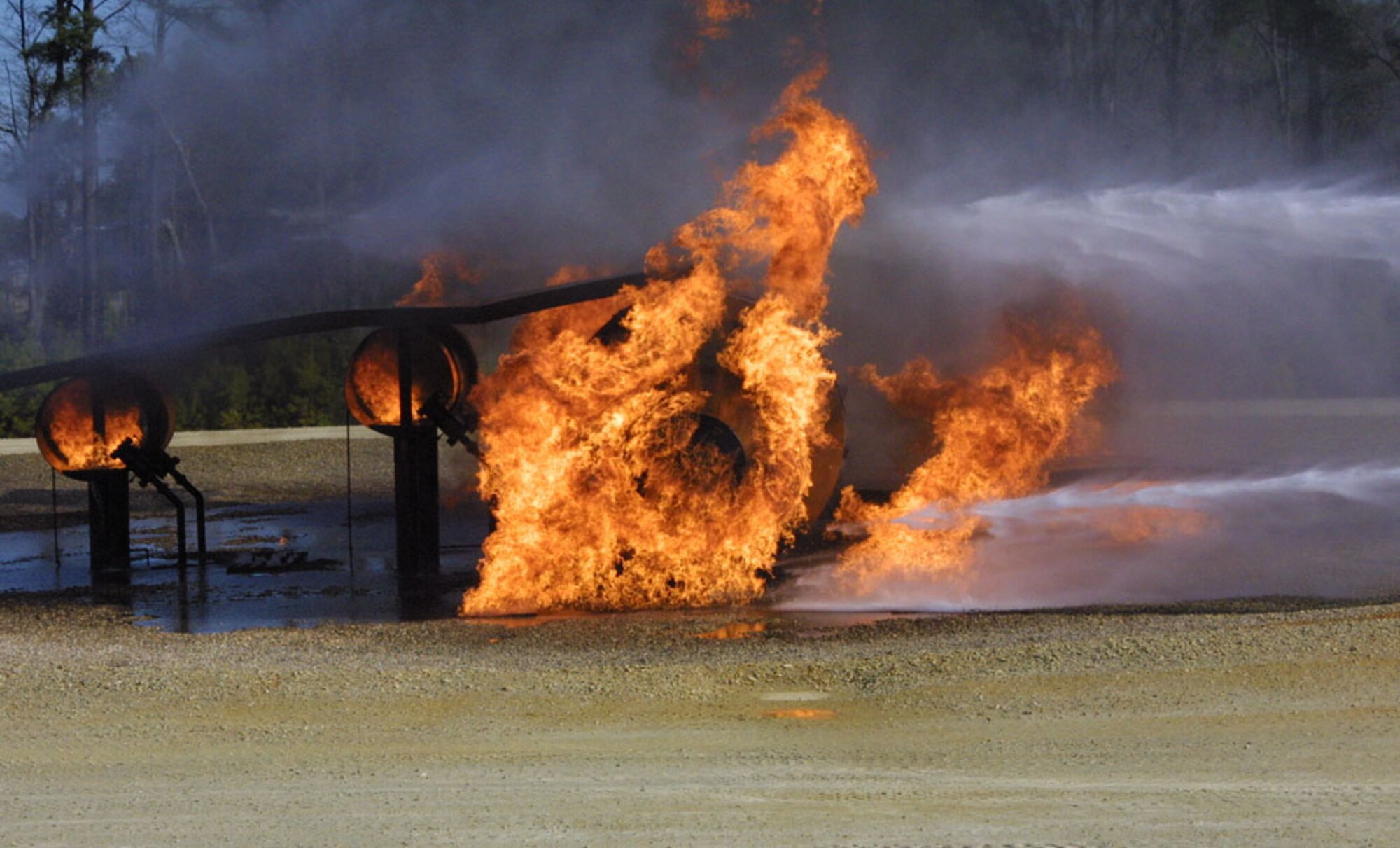 Firefighters from Pope Fire Department used a technique called "surround and drown" during training Jan. 26. Gen. Duncan McNabb, Air Mobility Command Commander, and Col. Timothy Zadalis, 43rd Airlift Wing Commander, each rode in a vehicle and operated a water cannon as the drivers maneuvered around the mock C-130.