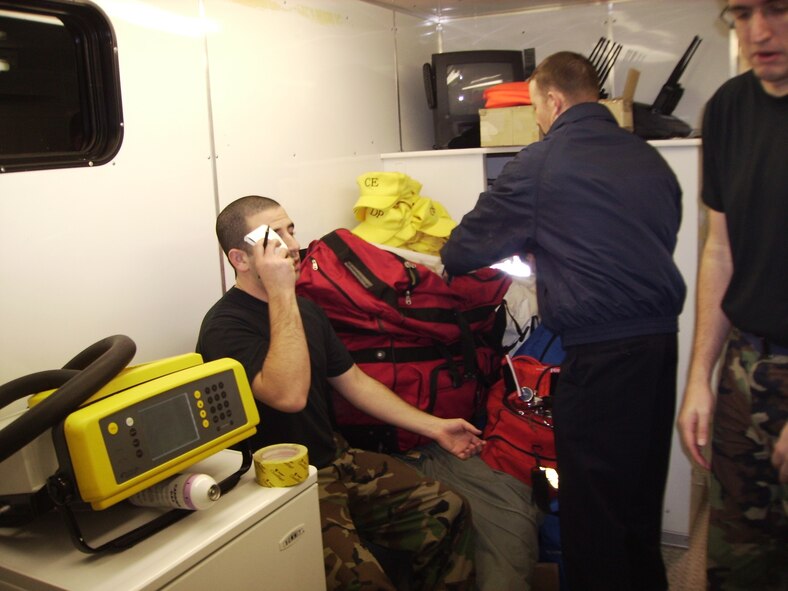 Ryan Burke, 341st Civil Engineer Squadron fire department member, checks the vital signs of Senior Airman Zalman Kosofsky before he suits up and enters the incident site on the Blackfeet Indian Reservation in Browning, Mont., Jan. 24. Team Malmstrom personnel were responding to a report of a suspicious package found in the Tribal Offices there.