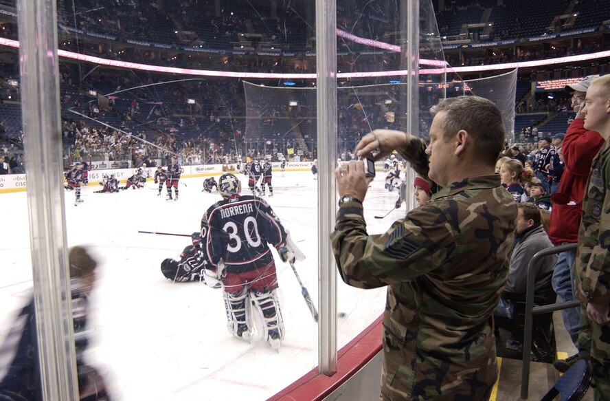 Tech. Sgt. Skeet Huskey takes pictures of the Columbus Blue Jackets during pre-game warm-up as they prepare to battle the Buffalo Sabres Jan. 26. Sgt. Huskey, with the 88th Communications Squadron, was one of nearly 100 Airmen from Wright-Patterson AFB who attended the game and were honored for their service by more than 18,000 fans at Nationwide Arena. Blue Jackets Center Sergei Fedorov purchased admission tickets and refreshments for the troops. (Air Force photo/Spencer P. Lane)