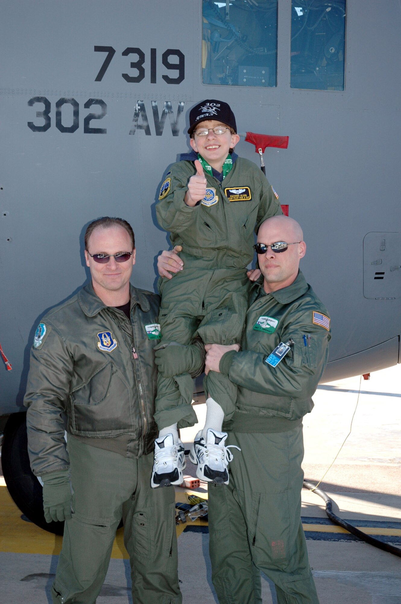 Master Sgt. Andre Nolte and Master Sgt. Derek Ashcroft hold Zachery Olsen on their shoulders after their tour of a C-130 Hercules Jan. 19 at Peterson Air Force Base, Colo. Zachery was made an honorary pilot through the 311th Airlift Squadron and the Make-A-Wish Foundation. Sergeant Nolte is a flight engineer, and Sergeant Ashcroft is a loadmaster, both with the 731st Airlift Squadron. (U.S. Air Force photo/Jennifer Ledford) 
