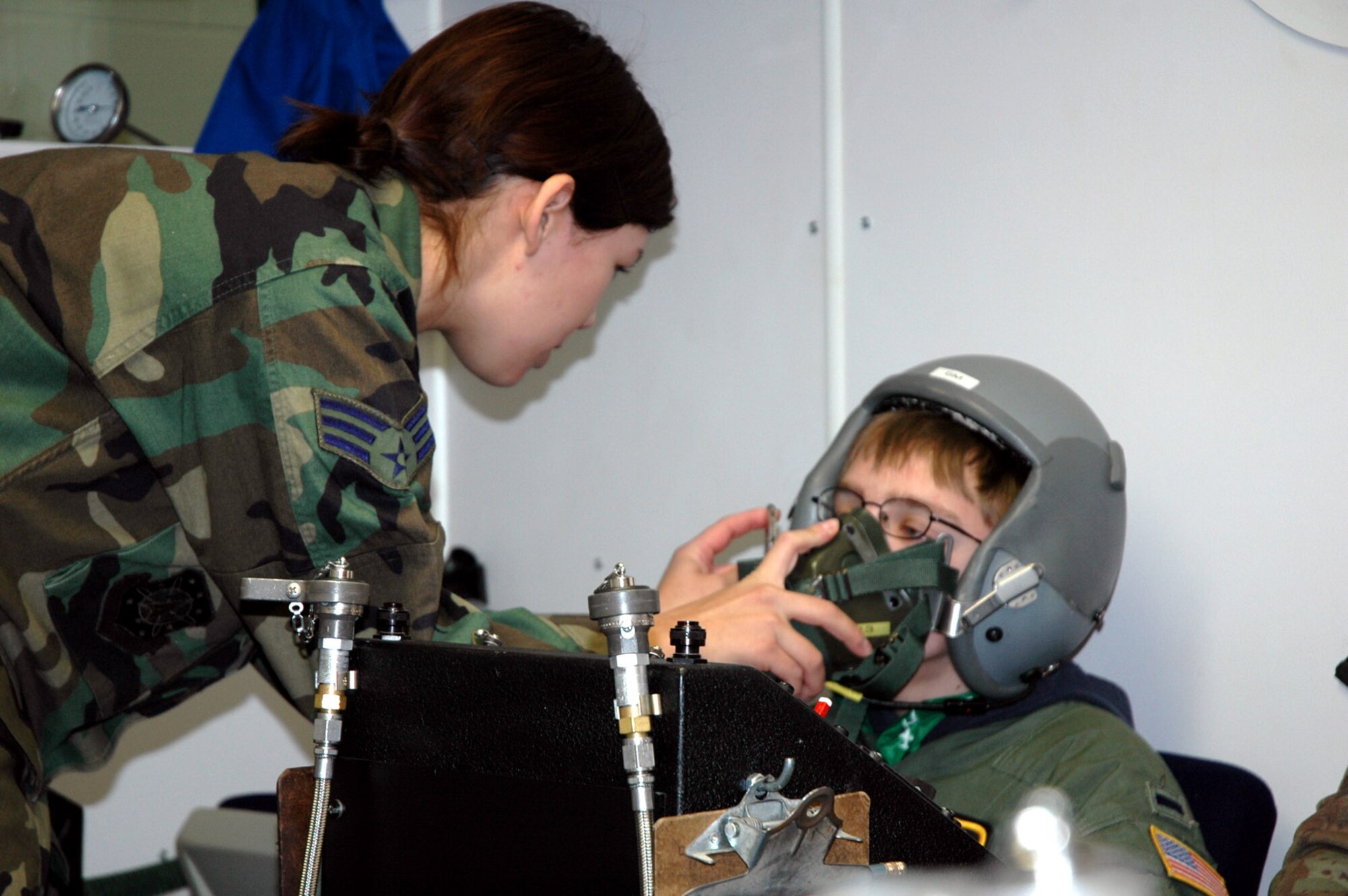 Senior Airman Sonrisa Flores fits a pilot's oxygen mask on Zachery Olsen Jan. 19 at Peterson Air Force Base, Colo. Zachery, who suffers from neurofibromatosis, was made an honorary pilot through the 311th Airlift Squadron and the Make-A-Wish Foundation. Airman Flores is an aerospace physiology journeyman with the 21st Aerospace Medicine Squadron. (U.S. Air Force photo/Jennifer Ledford) 
