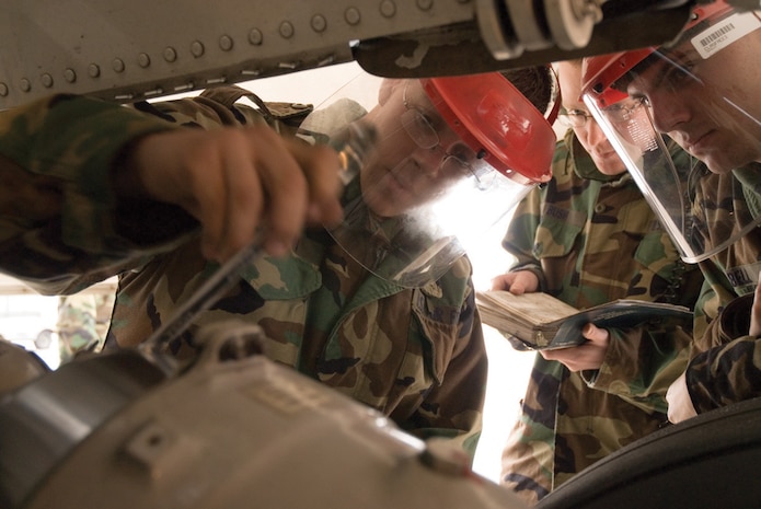 Airman Cody Hickman, 373rd Training Squadron C-17A APG crew chief course student, services the main landing gear strut with the help of Airmen Joseph Bush and Michael Bell, also students in the crew chief course on the Charleston AFB flightline Jan. 23. (U.S. Air Force photo/Senior Airman Sam Hymas)
 