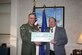 Michael Aimone, Air Force assistant deputy chief of staff for logistics, installations and mission support, presents Col. Rick Martin, 305th Air Mobility Wing commander, with a $20,000 check to fund McGuire’s energy conservation initiatives. As a part of AFSO 21, a team of 13 people from the Departments of Defense and Energy spent five days here, evaluating how to best conserve energy on base. 