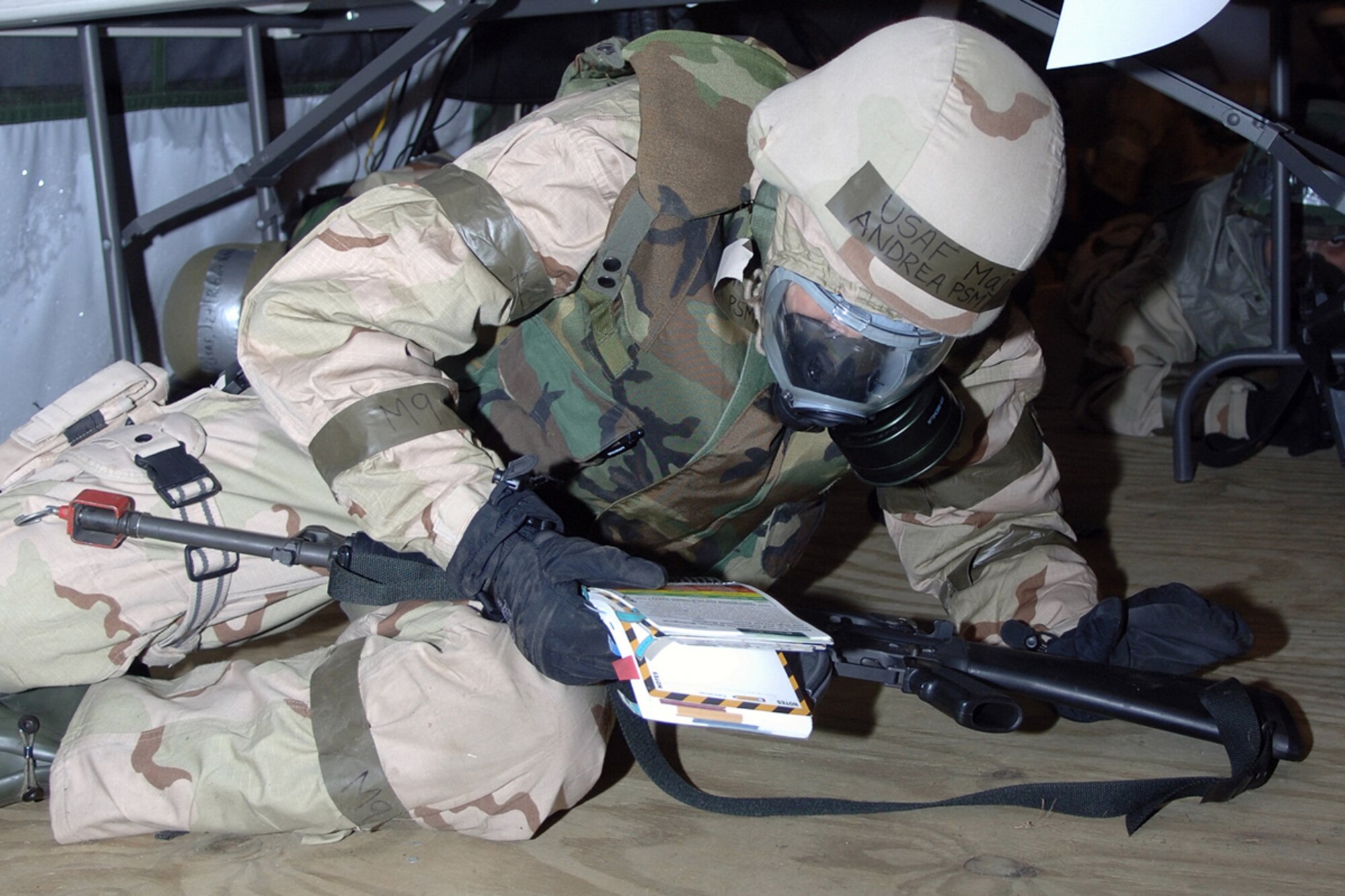 Hanscom AFB -- Maj. Andrea Psmithe, 66th Contracting Squadron commander, reads Air Force Manual 10-100  during the January Base Readiness Exercise at Hanscom’s Camp Patriot Jan. 26. Hanscom’s “deployed troops” experienced in-the-field conditions at Camp Patriot, an area designed to simulate combat conditions. Hanscom will hold BREs each month until the Operational Readiness Inspection in June. U.S. Air Force photo by Jan Abate
