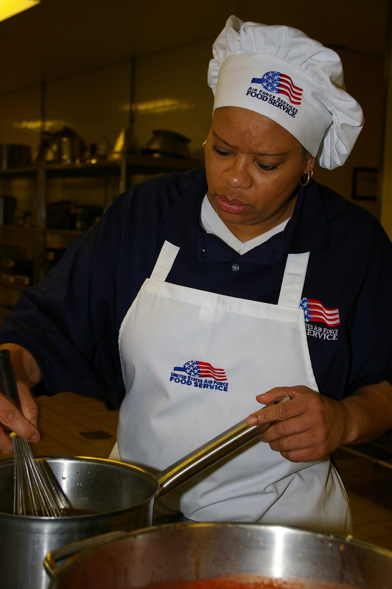 Rose St. John, 100th Services Squadron Gateway Dining Facility first cook, and Ministry of Defence employee, prepares teriyaki sauce Tuesday for the lunchtime special of teriyaki chicken. (U.S. Air Force photo by Karen Abeyasekere)