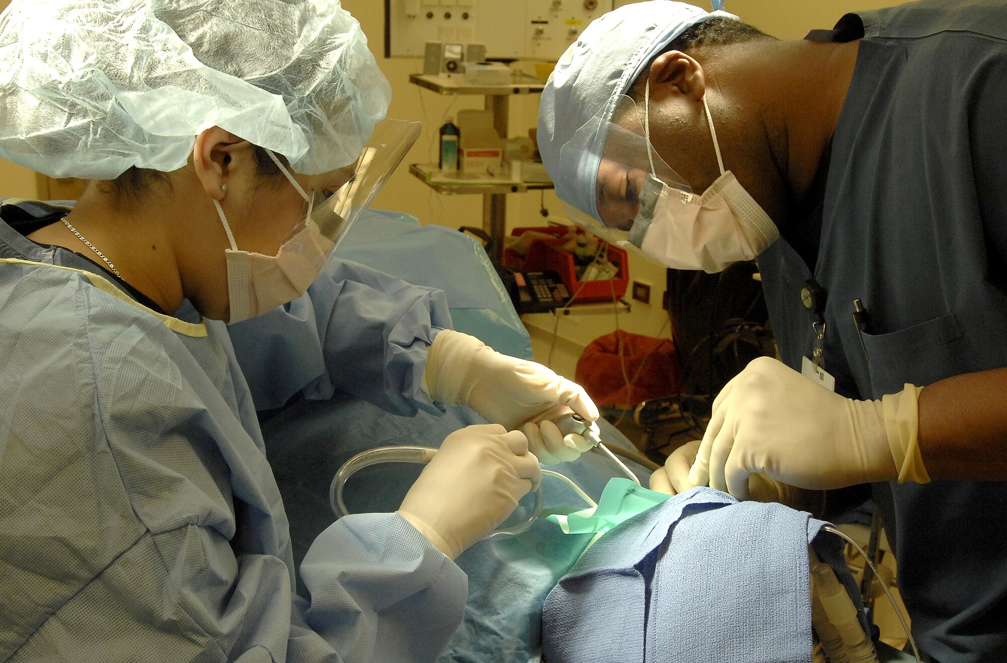 Senior Airman Sarai Gapetz, 31st Dental Squadron dental technician, left, assists Capt. Corbet Ellison, 31st DS pediatric dentist, during dental rehabilitation surgery. February is National Children’s Dental Health Month and throughout the month, the dental squadron will teach Aviano school students about the importance of proper dental hygiene. (Photo by Airman 1st Class Liliana Moreno)