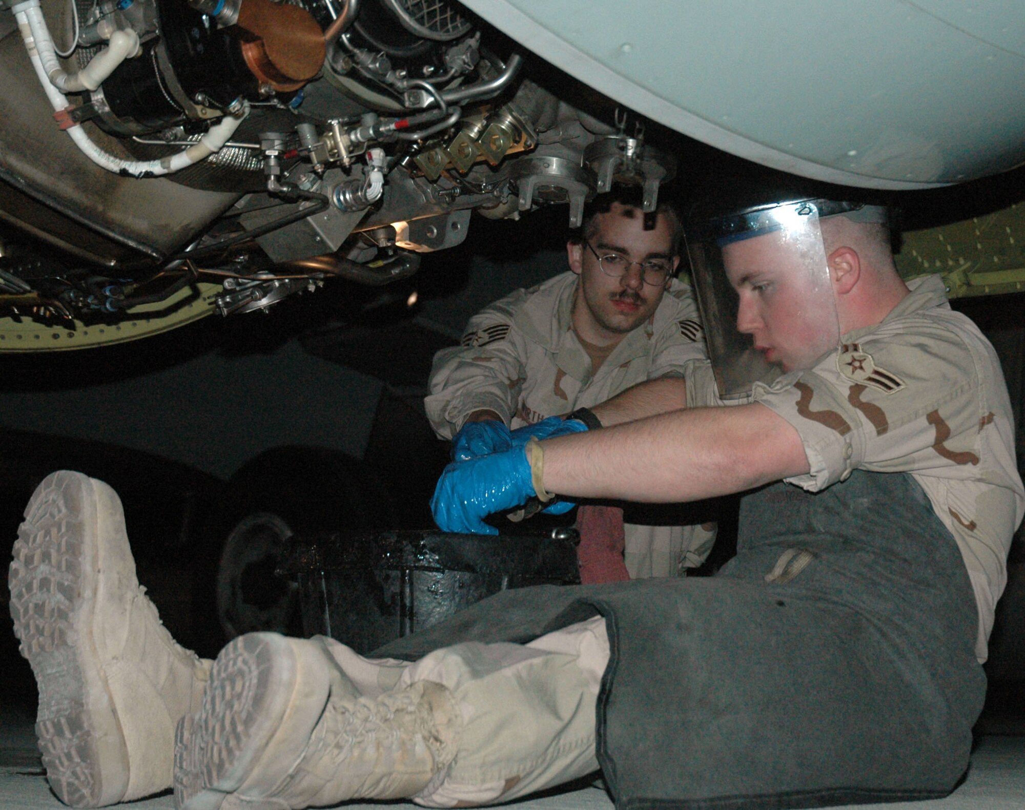 Staff Sgt. Daniel Wirth oversees Airman 1st Class Christopher Clement as he inspects the chip detectors in the oil system of an RC-135 Rivet Joint aircraft during the post-flight inspection. Chip detectors are magnets that locate abnormal wear by picking up metal particles. Both are assigned to the 379th Expeditionary Aircraft Maintenance Squadron. (U.S. Air Force photo\Senior Airman Erik Hofmeyer)