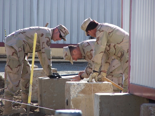 Kirkuk Regional Air Base, Iraq – (Left to Right) Tech. Sgt. Clay Bucy, Master Sgt. Will Jobson and Tech. Sgt. John LeMaster assigned to the 506th Expeditionary Civil Engineer Squadron level concrete footings for a Pod which will house base airman. Air Force reservists are deployed from the 445th Civil Engineer Squadron at Wright-Patterson AFB, Ohio. (U.S. Air Force curtsey photo).
