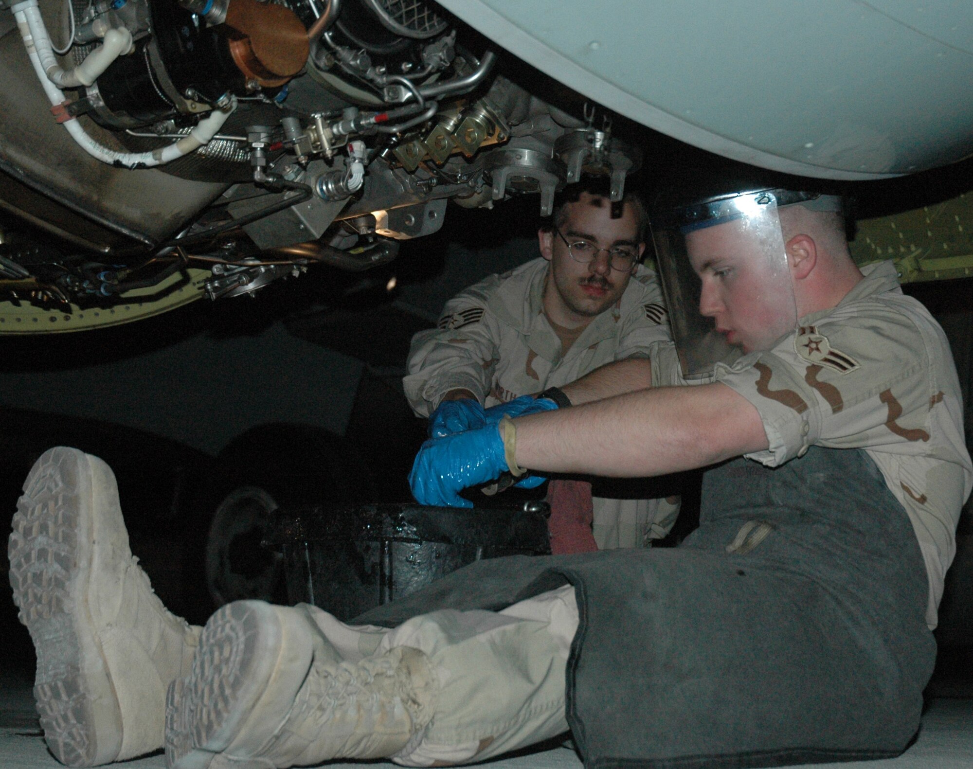 Airman 1st Class Christopher Clement (right), 379th EAMXS aerospace propulsion apprentice, inspects the chip detectors in the oil system of an RC-135 Rivet Joint. Chip detectors are four magnets that locate abnormal wear by picking up metal particles, and are checked every 60 hours. Staff Sgt. Daniel Wirth (left), 379th EAMXS aerospace propulsion craftsman, oversees the post-flight inspection. (U.S. Air Force photo by Senior Airman Erik Hofmeyer)

