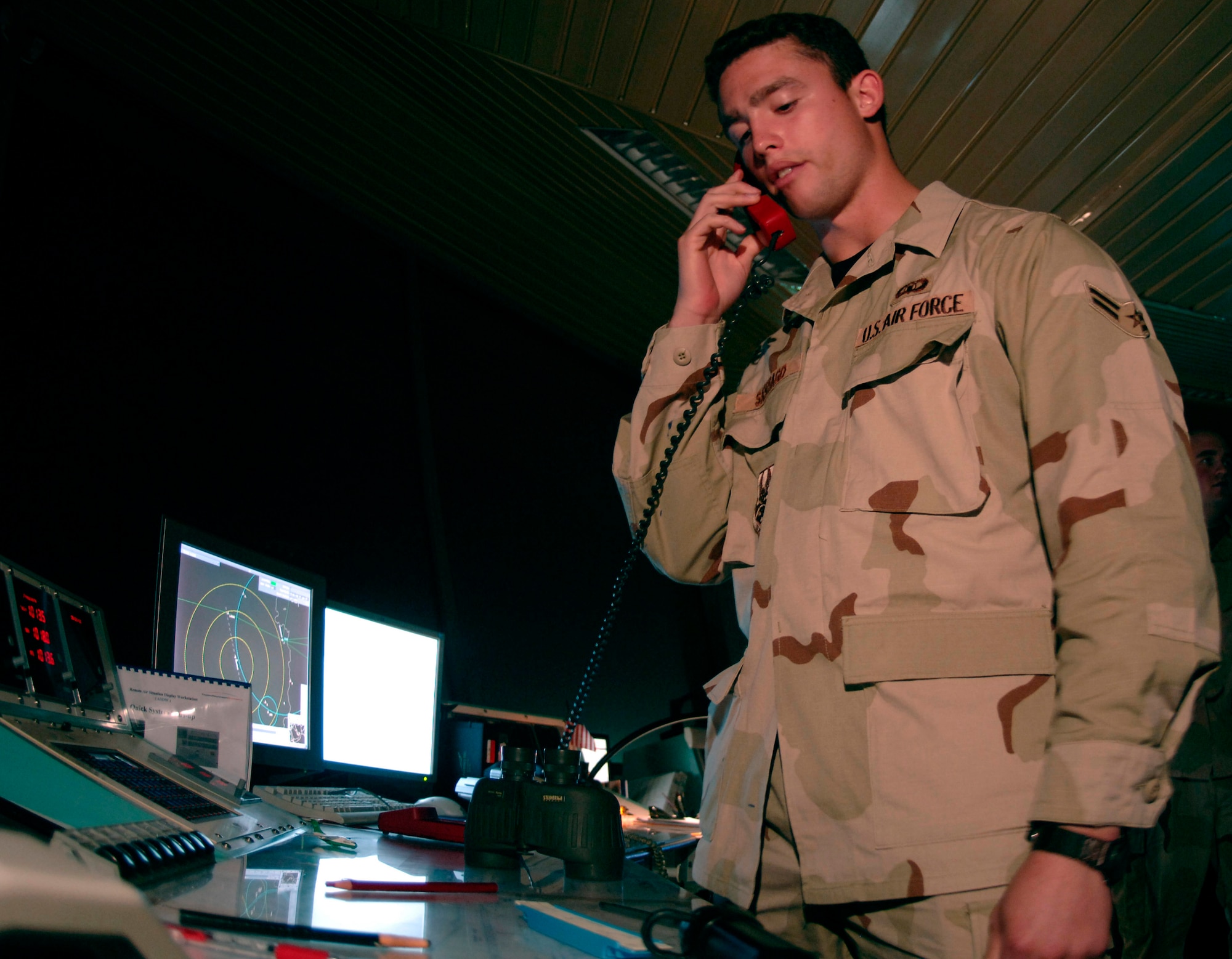 Airman 1st Class Carlos Santiago, 379th EOSS air traffic control specialist, works the “local control” position in the air traffic control tower clearing aircraft for takeoff landings. He coordinates aircraft flight plans with airfield management, ensuring safe and efficient use of runway and air space. (U.S. Air Force photo by Staff Sgt. David Miller)