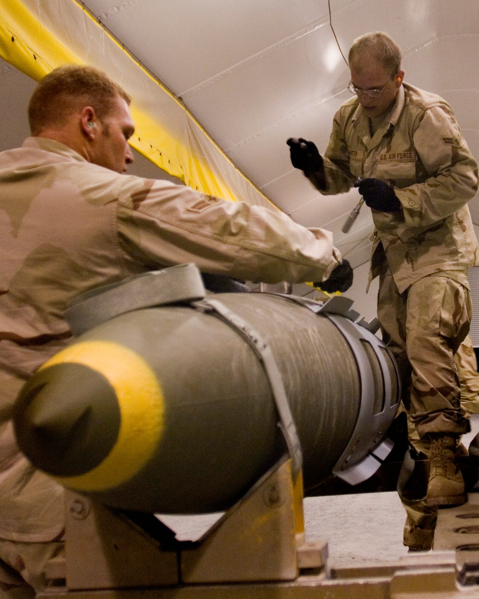 Airmen 1st Class Cory Shinn (left) and Andrew Hester (right), 379th Expeditionary Maintenance Squadron Munitions Flight crew members, build a GBU-31 bomb to replenish expended munitions. (U.S. Air Force photo by Tech. Sgt. Cecilio Ricardo)
