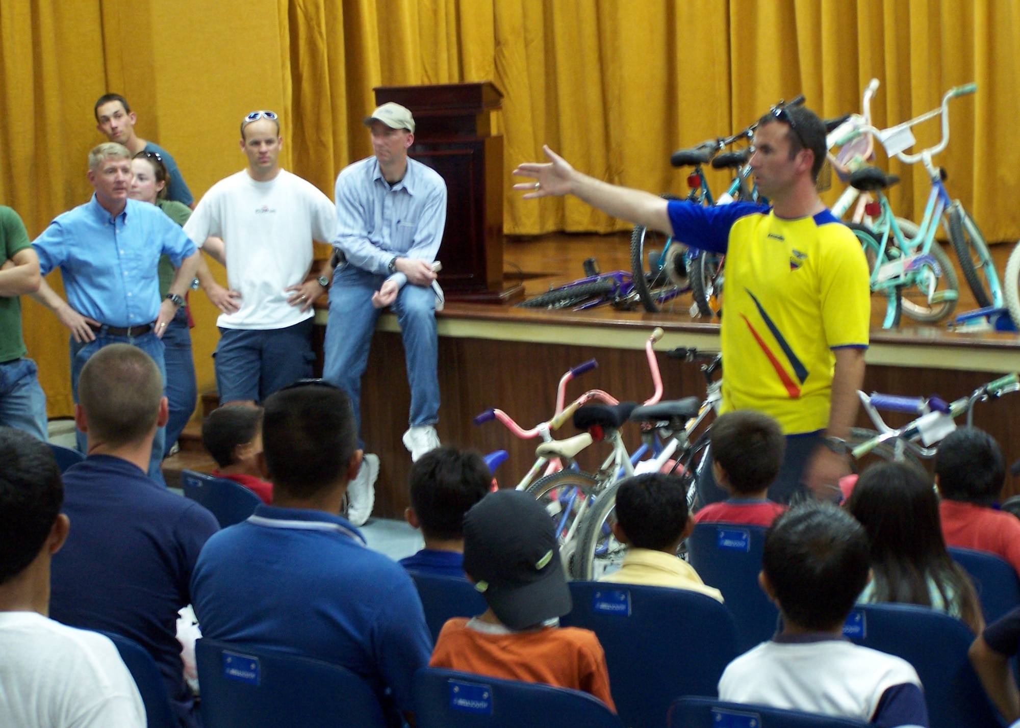 Maj. Chris Buckley, 478th Expeditionary Operations Squadron and lead volunteer for the English class at the Albergue School in Manta, Ecuador, tells the students the process for retrieving their donated bicycles.  (U.S. Air Force official photo)