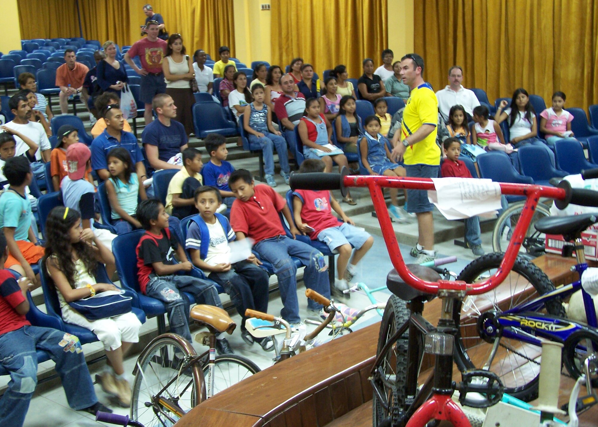 Maj. Chris Buckley, 478th Expeditionary Operations Squadron and lead volunteer for the English class at the Albergue School in Manta, Ecuador, tells the students the process for retrieving their donated bicycles.  (U.S. Air Force official photo)