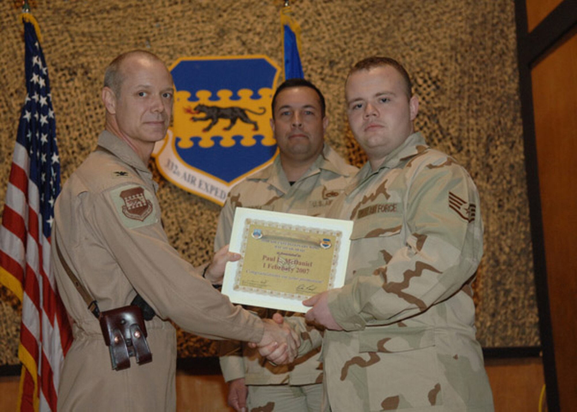 02/02/2007 -- SOUTHWEST ASIA -- Senior Airman Paul McDaniel, 35th Maintenance Operations Squadron, receives a certificiate from his deployed commander at Balad Air Base, Iraq. (U.S. Air Force photo)