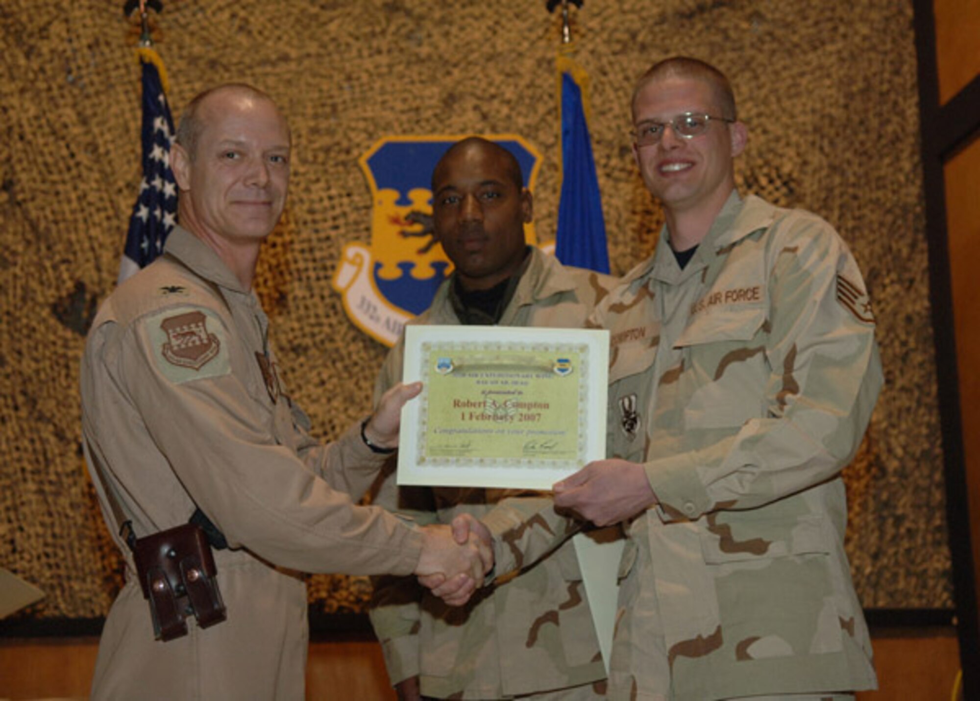 02/02/2007 -- SOUTHWEST ASIA -- Senior Airman Robert Compton, 35th Aircraft Maintenance  Squadron, receives a certificiate from his deployed commander at Balad Air Base, Iraq. (U.S. Air Force photo)