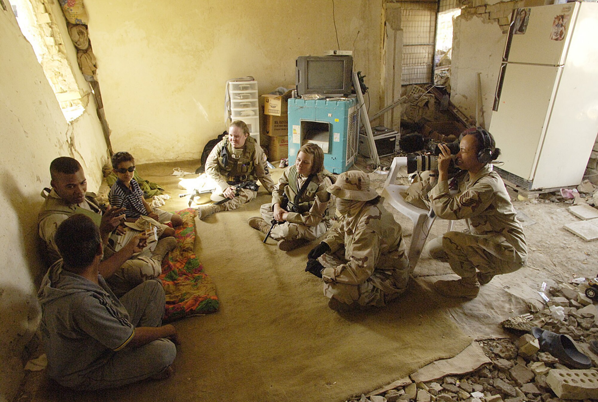 01/27/2007 -- SOUTHWEST ASIA -- Tech. Sgt. Renee Crisostomo, in back with camera, is currently deployed to Al Udeid under the Central Command PA team, records an interview several other Airmen are conducting with a family in Baghdad recently.  She is traveling between Afghainstan and Iraq telling the Air Force story from down-range.  Sergeant Cristostomo is assigned to Misawa American Network Forces, Detachment 12. (U.S. Air Force photo)