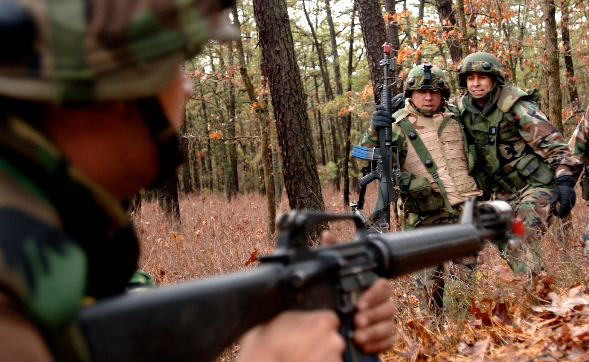 Real-world battlefield scenarios are a vital part of combat skills traing conducted at Ft. Dix, New Jersey. Two Airmen on patrol, of which one is 'injured', prepare to surrender to their captor wielding an M-16 rifle.