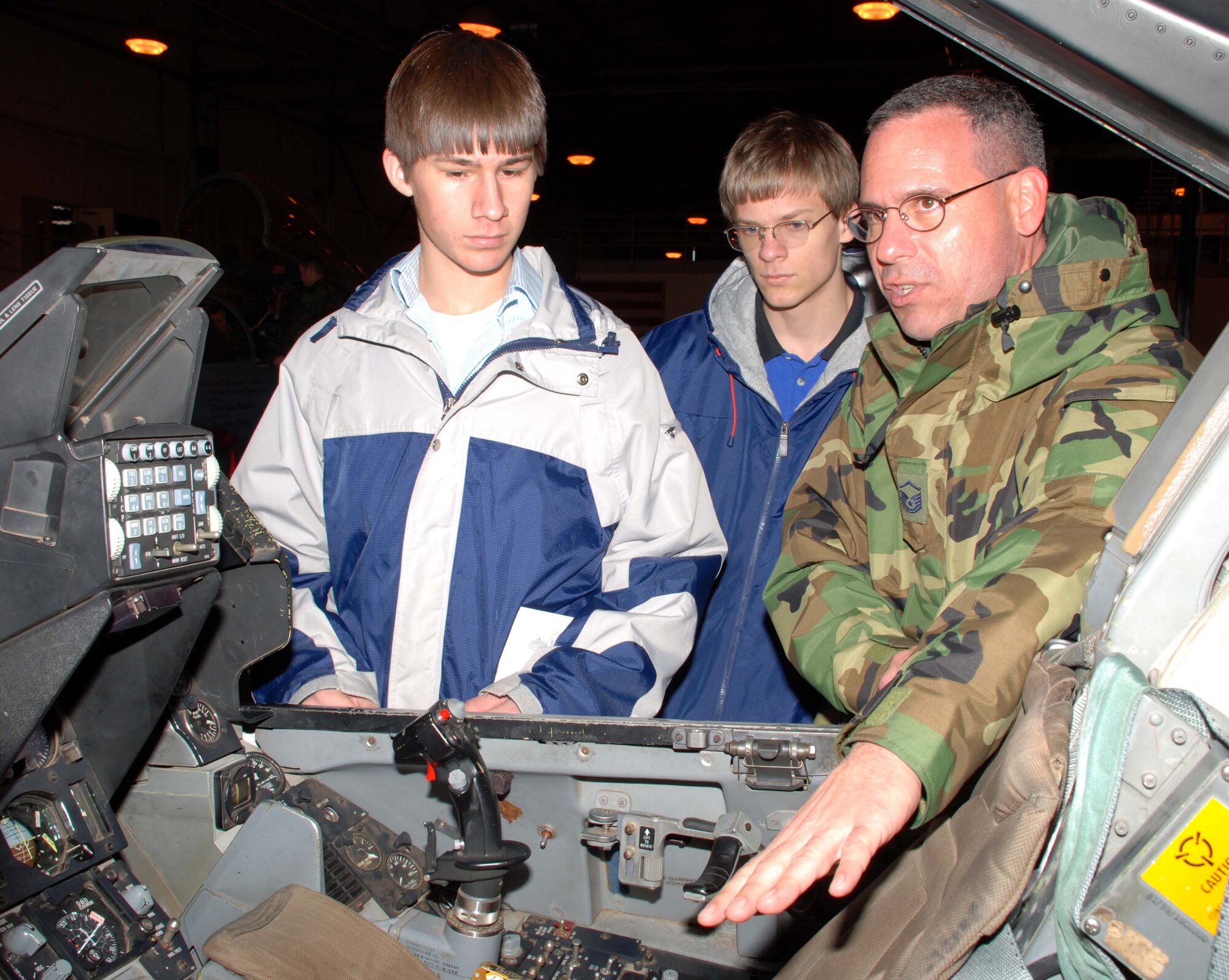 Dustin Trevino from Petrolia High School and Brandon Tiedeman from City View High School get an upclose view of an F-16 cockpit. Master Sgt. Peter Bushnell, Flight Superintendent Fighter Avionics,  explains how training is conducted on the F-16 Ground Instructional Training Aircraft. Mr. Trevino and Mr. Tiedeman participated in the annual Ground Hog Job Shadow Day. (U.S. Air Force photo/Tech. Sgt. Jennifer Isom)