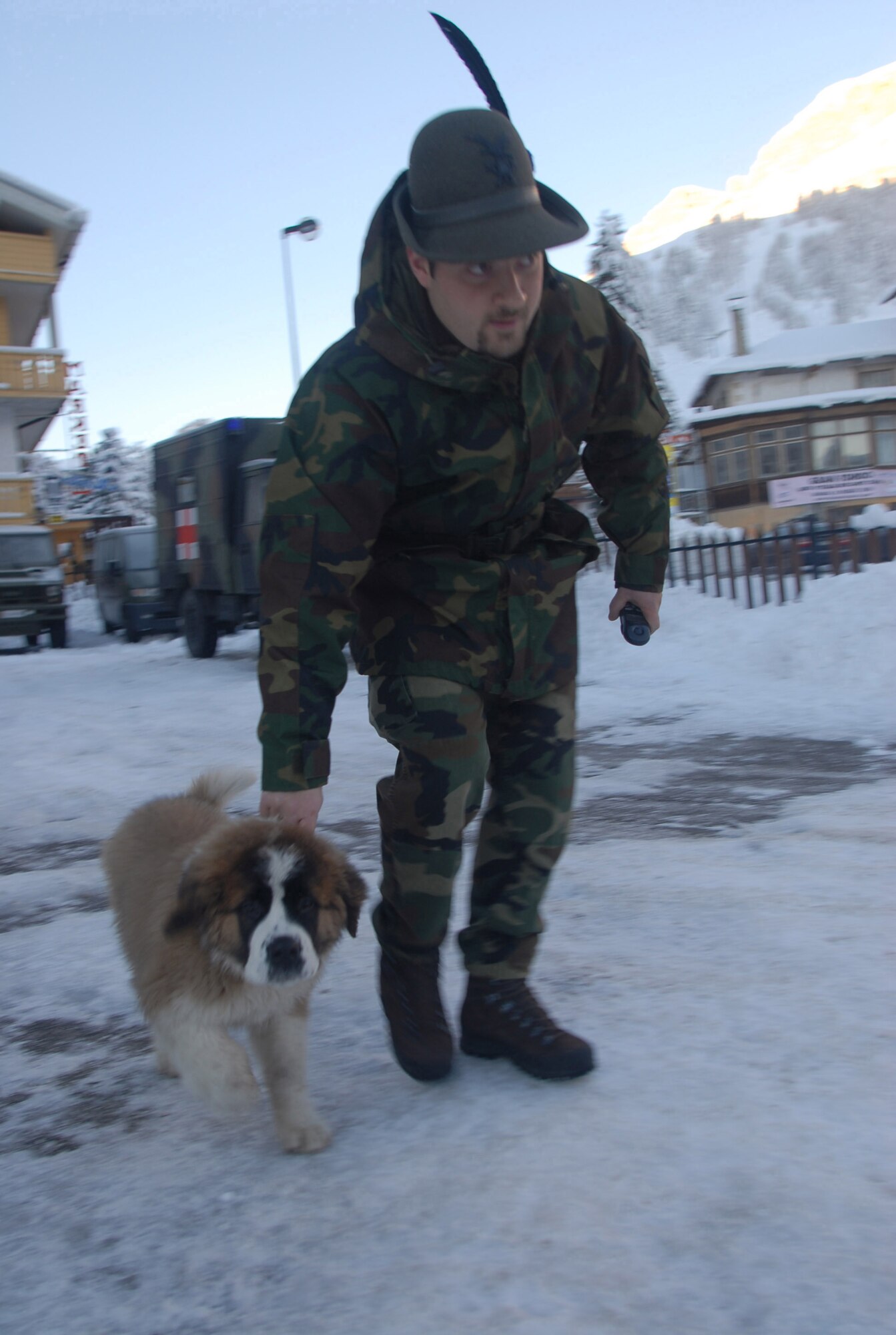 By Seth Robson
12/11/06 - An Alpini with his distictive feathered hat guides a mountain dog to his kennel at Arabba, Italy.