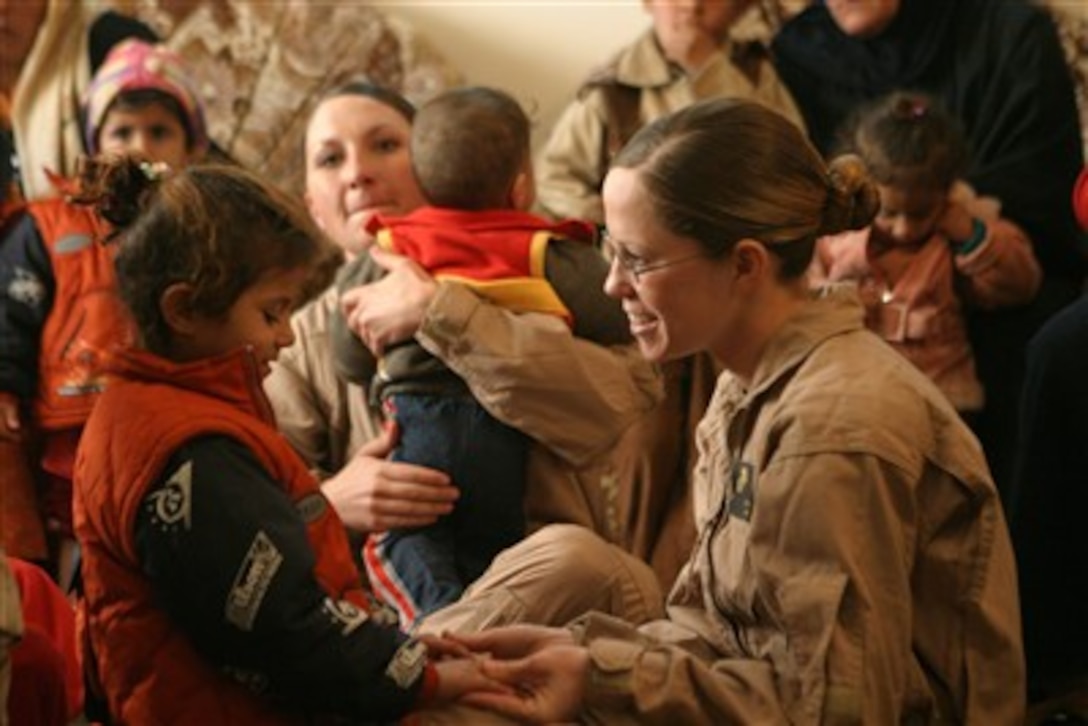 Sgt. Kimberly Taylor, U.S. Marine Corps, plays with an Iraqi child during an Iraqi women's engagement in Baghdaddi, Iraq, on Jan. 24, 2007.  Taylor is attached to the Marine Wing Support Squadron.  